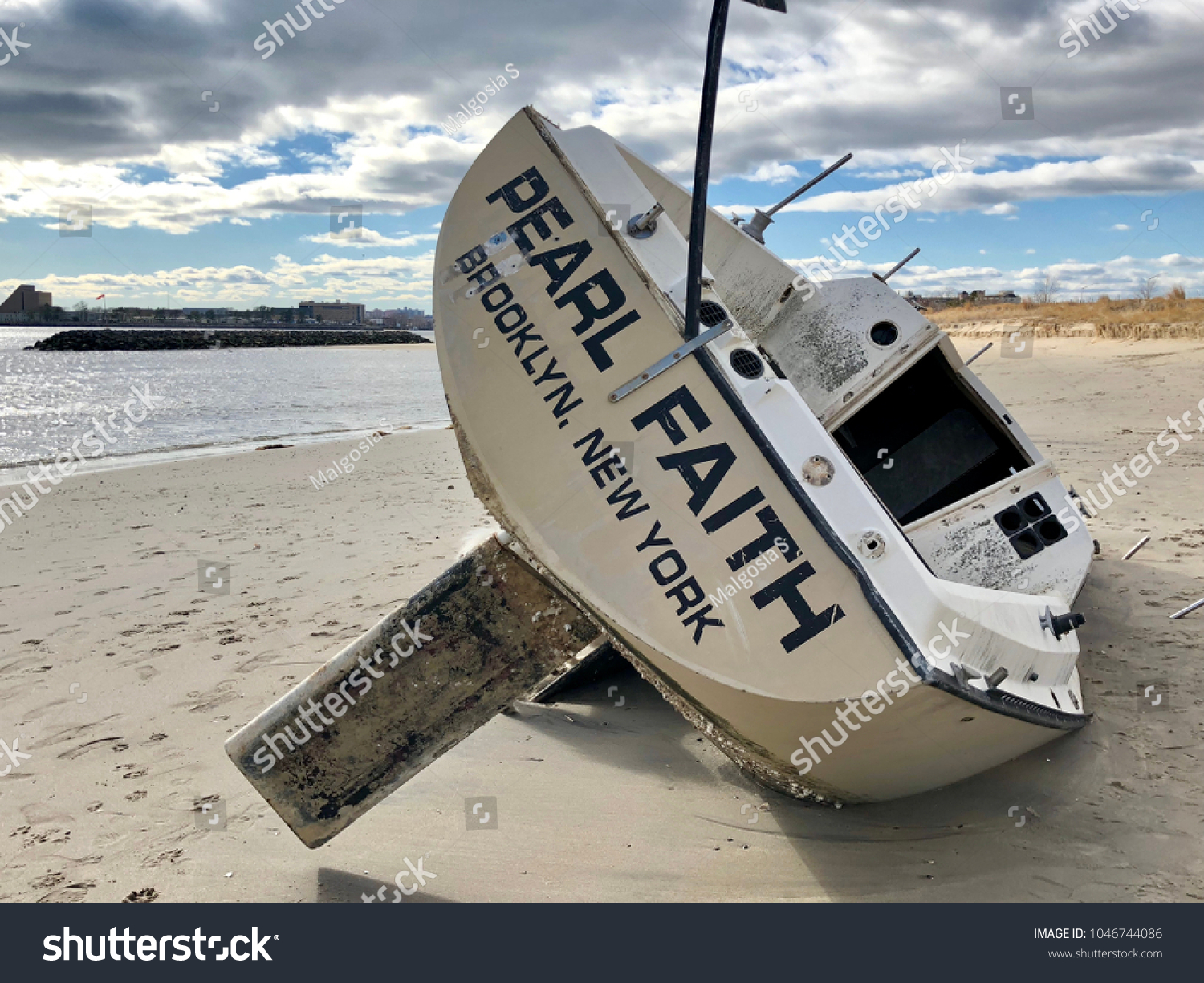 Overturned boat washed ashore by strong storm on Plumb Beach, Brooklyn, NY.