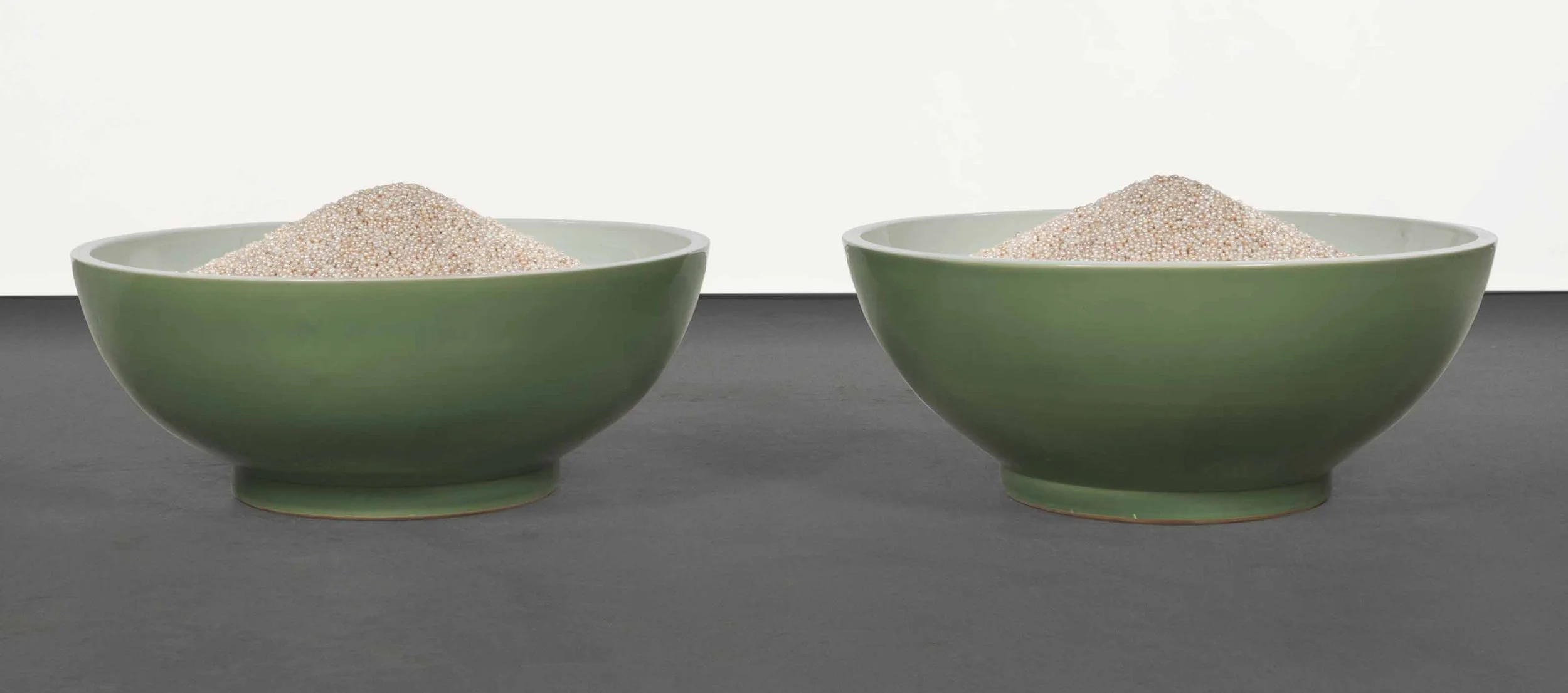 Image of two green bowls, each containing a mound of small pearls.