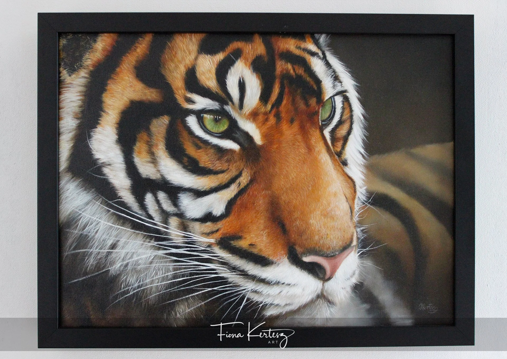 Framed original oil painting  by Fiona Kertesz of a New Zealand a close-up of a tiger's face showing green eyes and intricate fur detail.