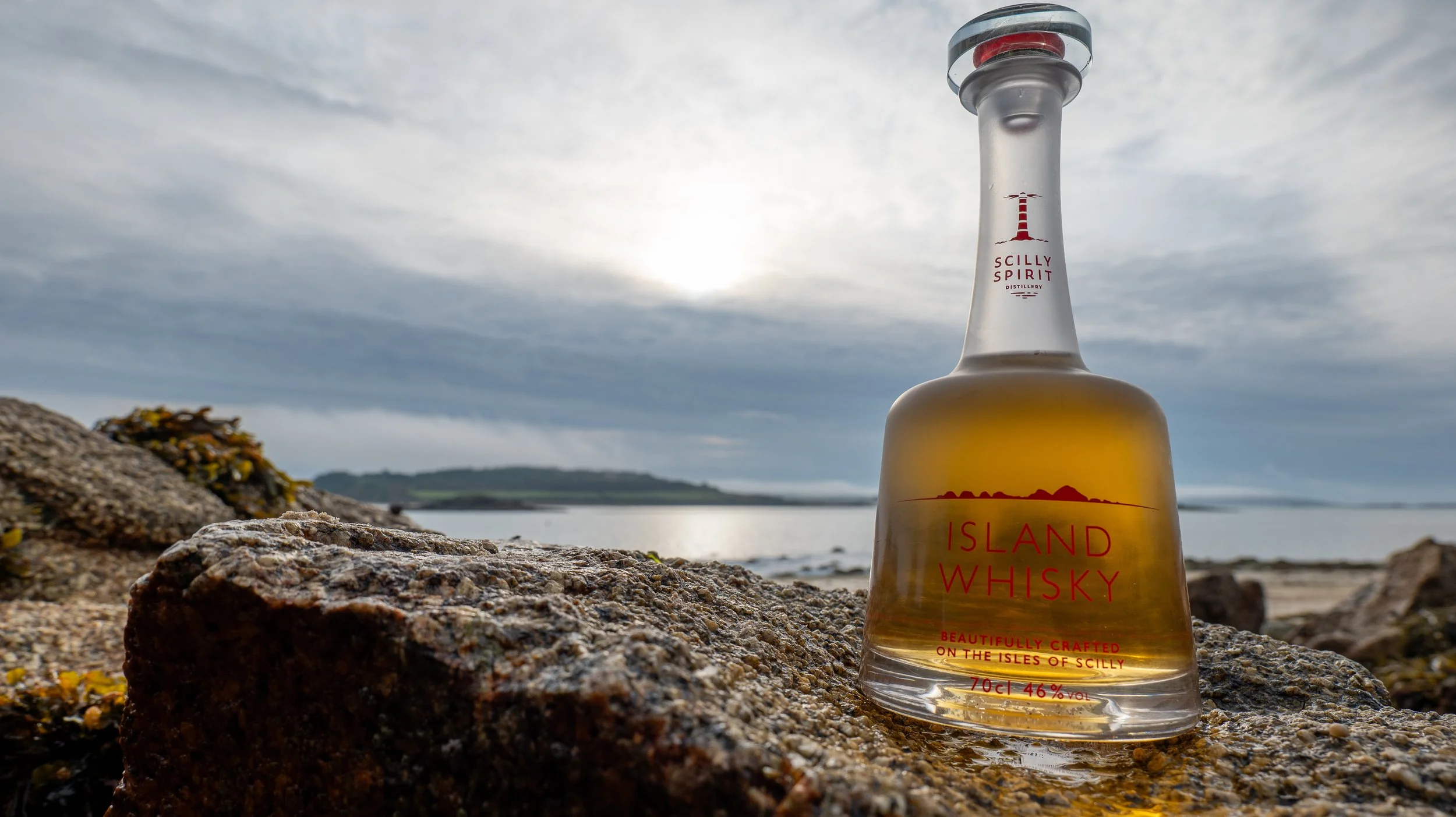 Bottle of Island Whisky on Rocks, St Marys in background