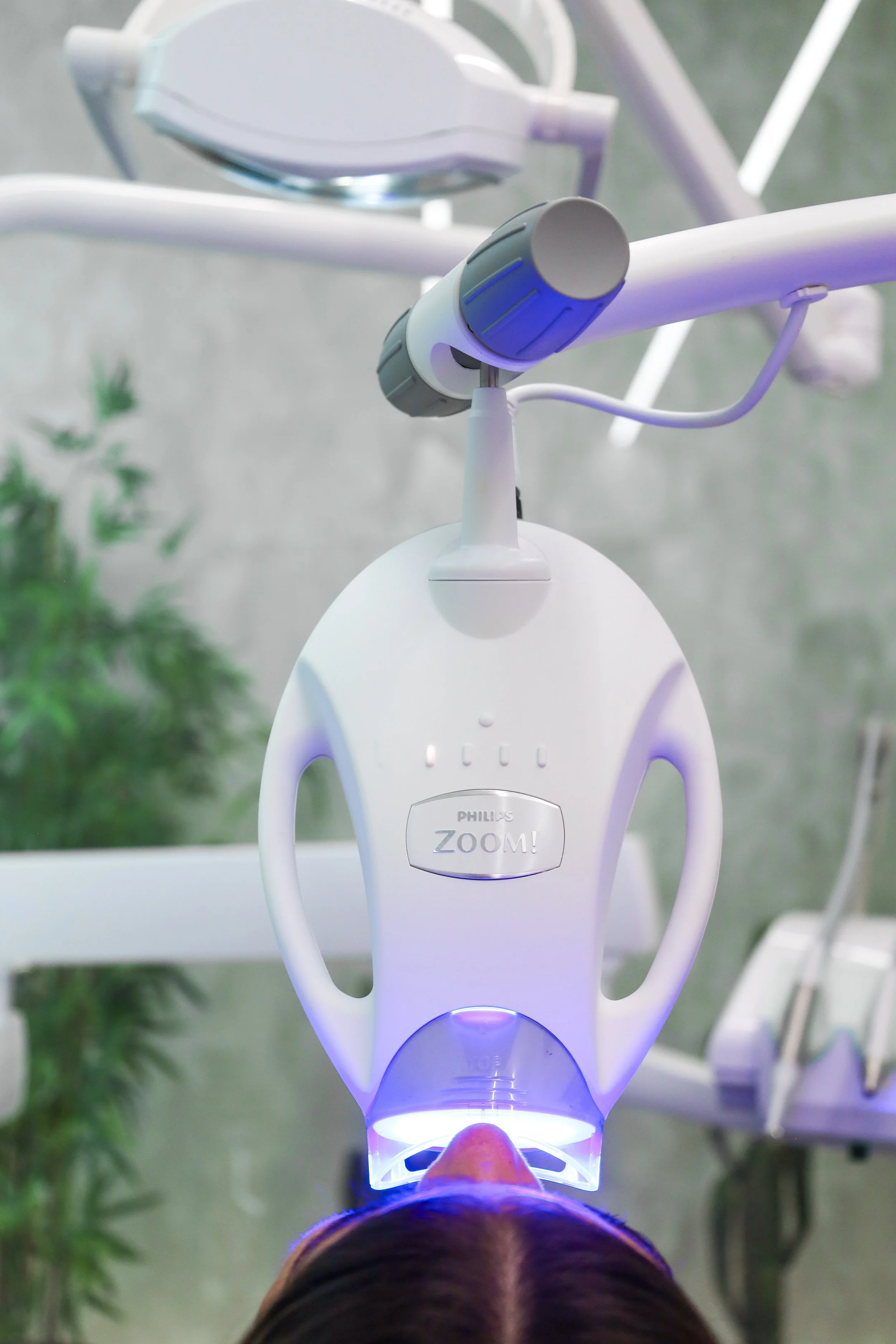 Philips Zoom teeth whitening device in use on a patient in a dental clinic.