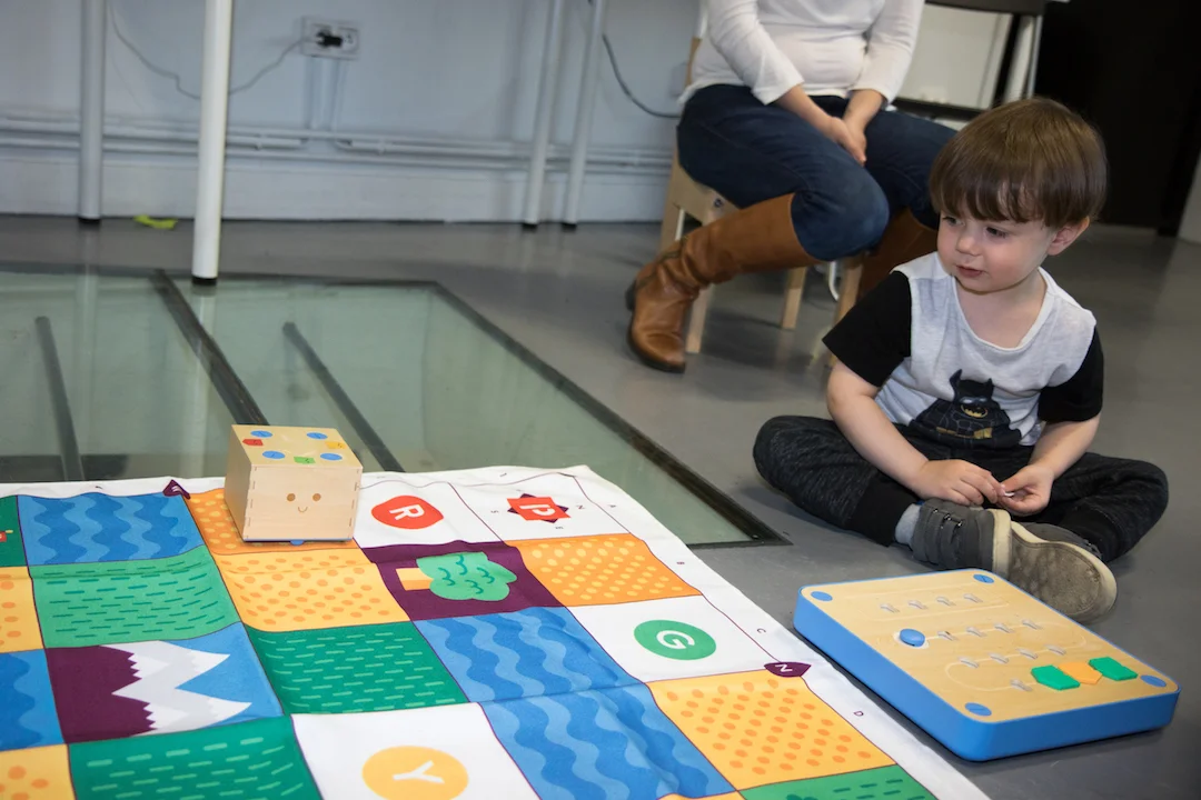 Un enfant de 3 ans observe son programme à l'oeuvre, d'un air plutôt satisfait.
