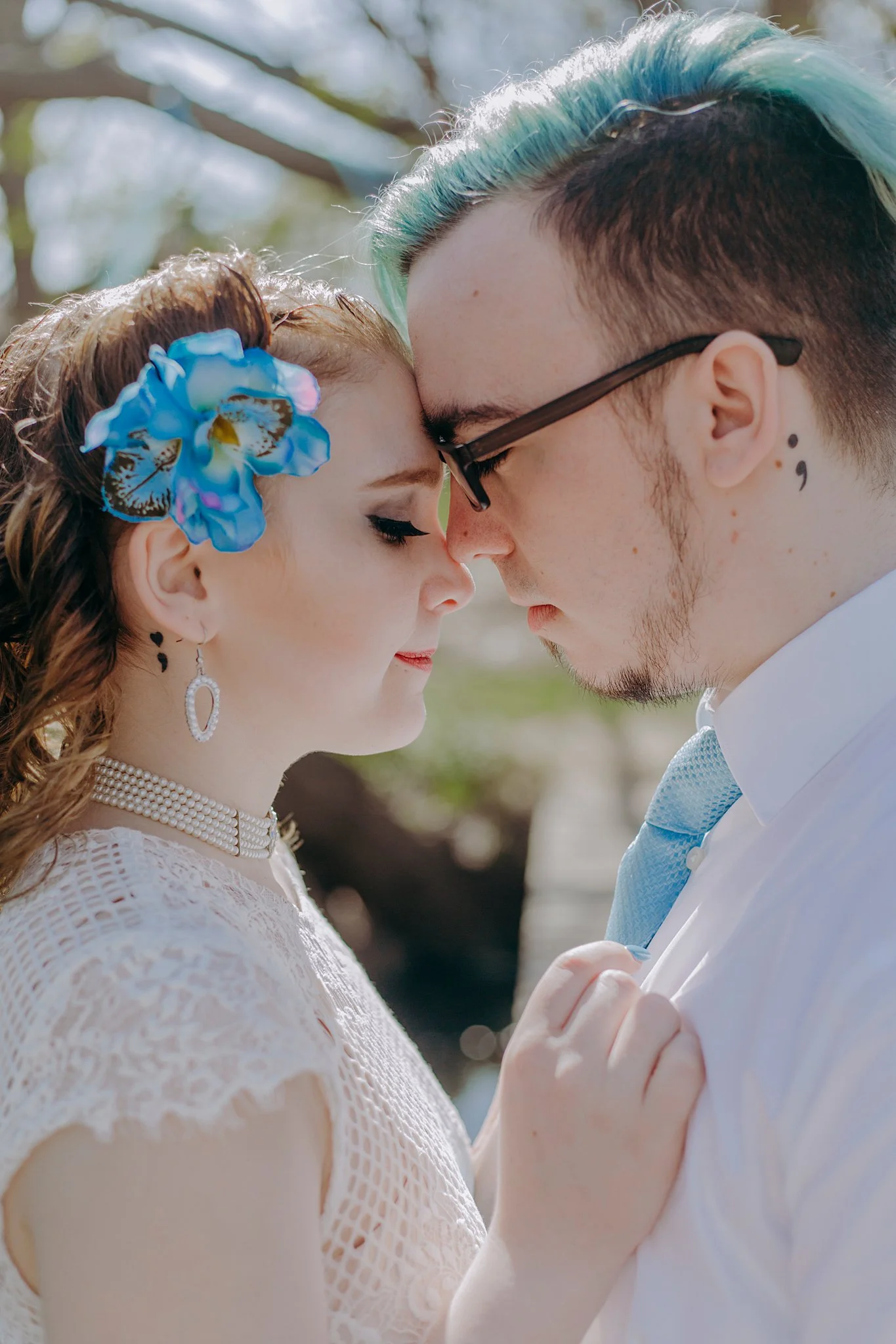 A recently eloped couple puts their foreheads together, closing their eyes and taking in the moment