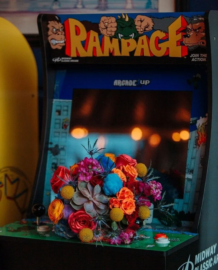 Seriously one of my favorite photos- combining a wedding with an old-school arcade game? YES PLEASE! Also how amazing is this vibrant bouquet from @blumzbyjrdesigns I'm in loveeeee!.⁠
.⁠
.⁠
.⁠
#michiganphotographer #michiganphotography #grandrapidsmi