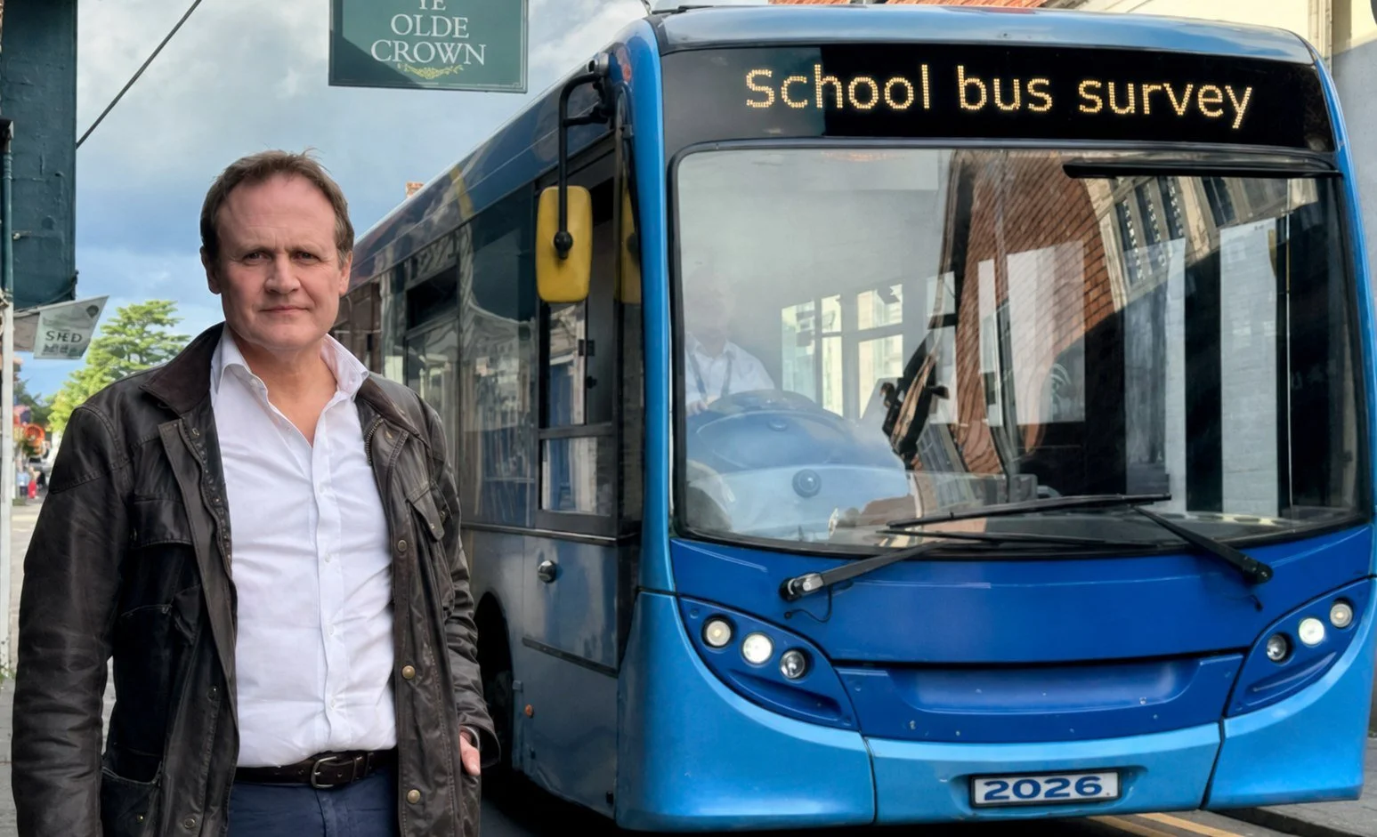 Tom Tugendhat beside a school bus