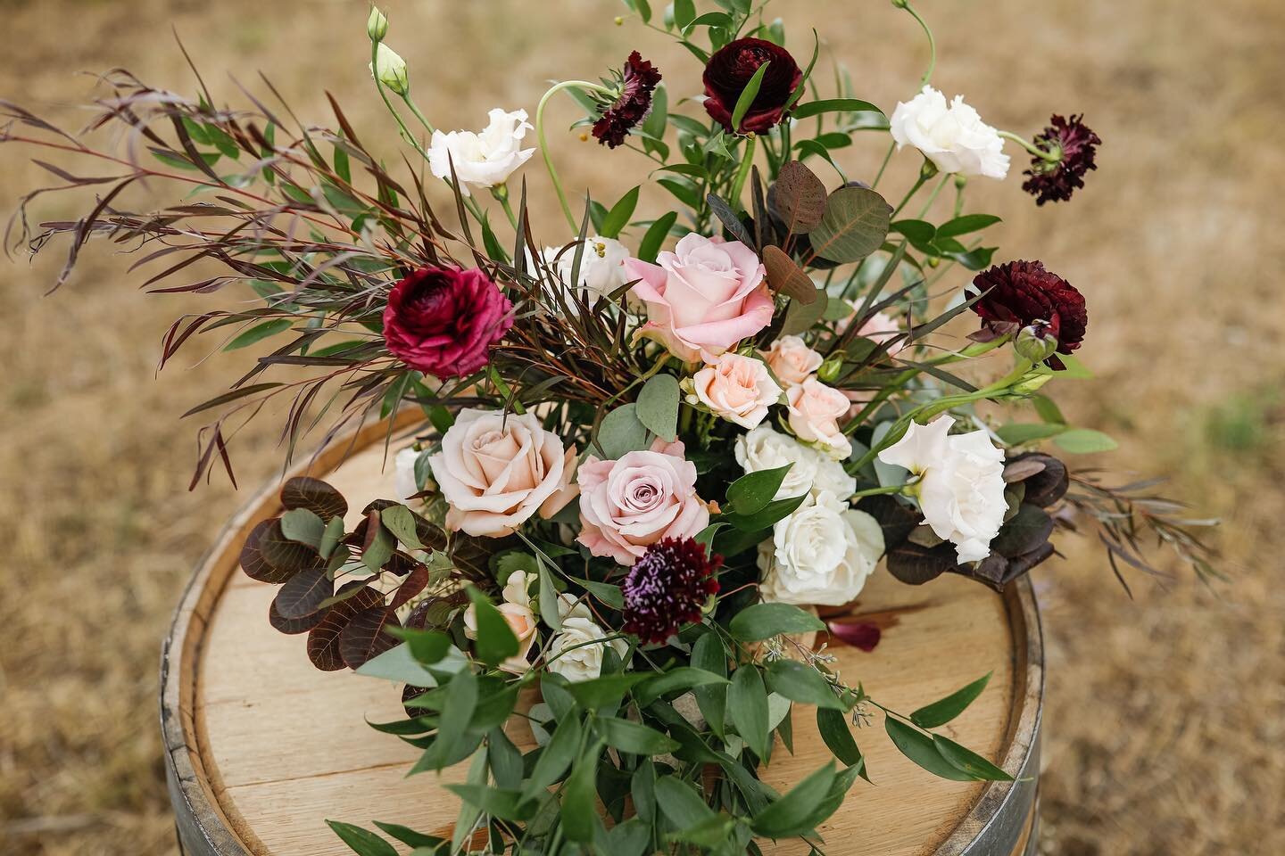 I often have the opportunity to create wine barrel  florals for the aisle entrance statement. There is something special about the way Scabiosa and Ranunculus bend and curve in arrangements like this I love.
Photo Credit: @saranagelphotography

#loca