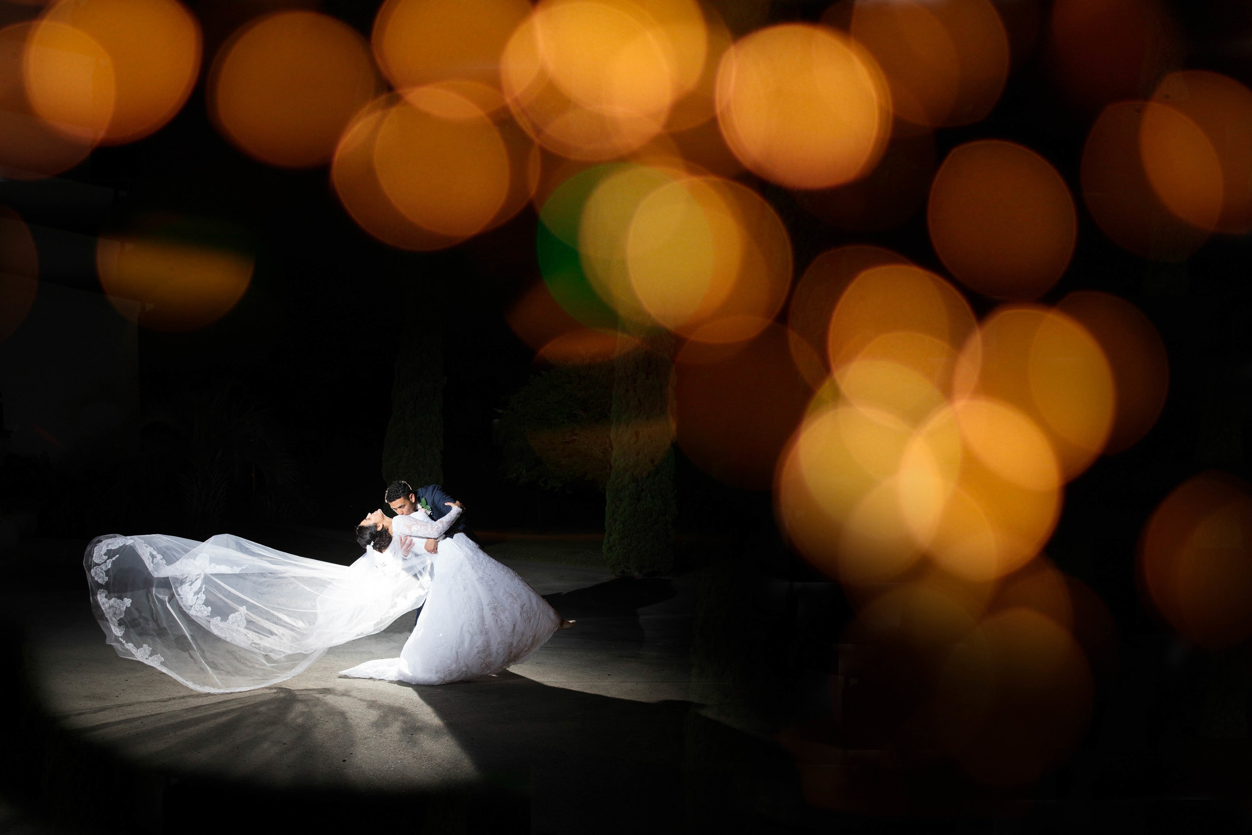  Stylish and dramatic shot of newlywed couple dancing together 