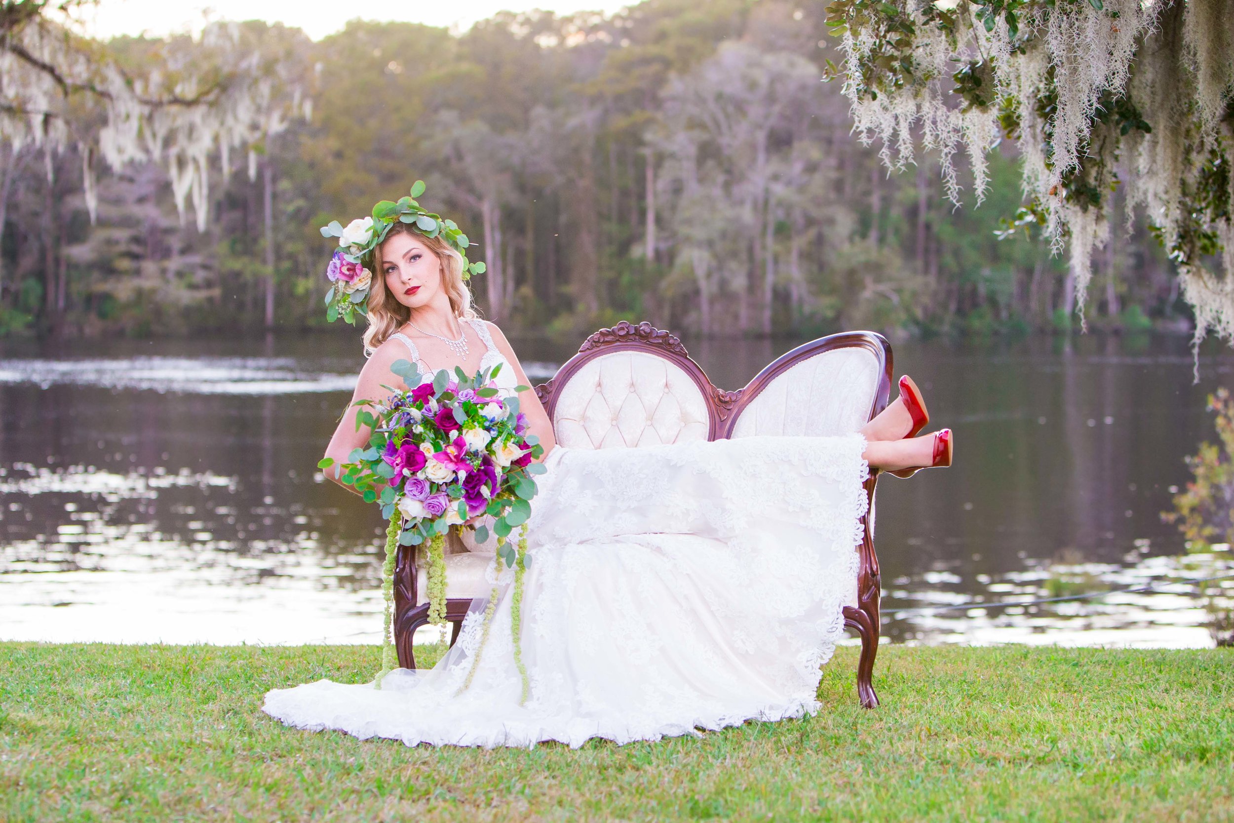  Bride lounges on a vintage couch on the waterfront during golden hour 