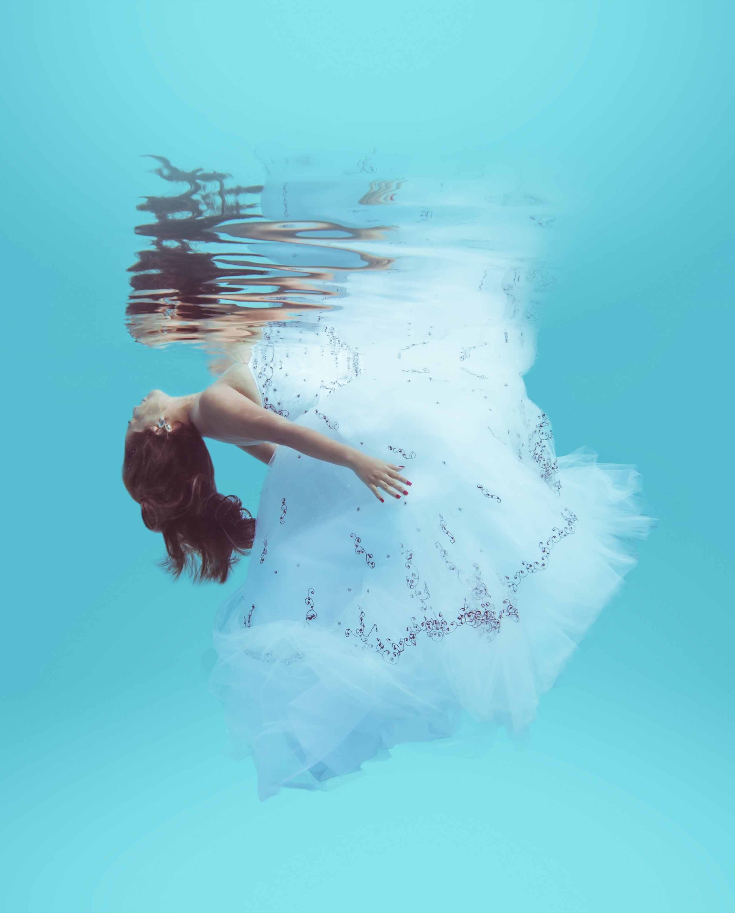  Bride floats elegantly under the water in her wedding dress 