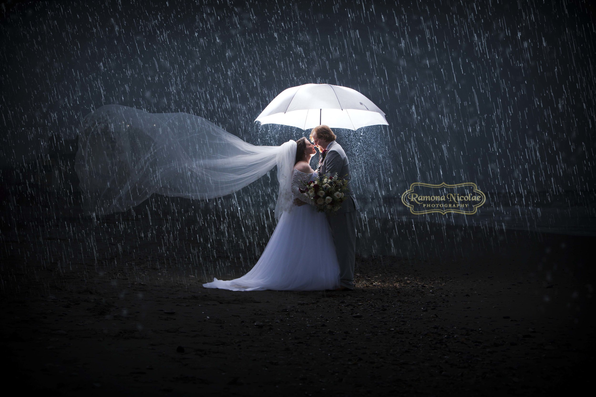 bride and groom embracing under lit umbrella in the rain in myrtle beach by ramona nicolae photogrpahy.jpg