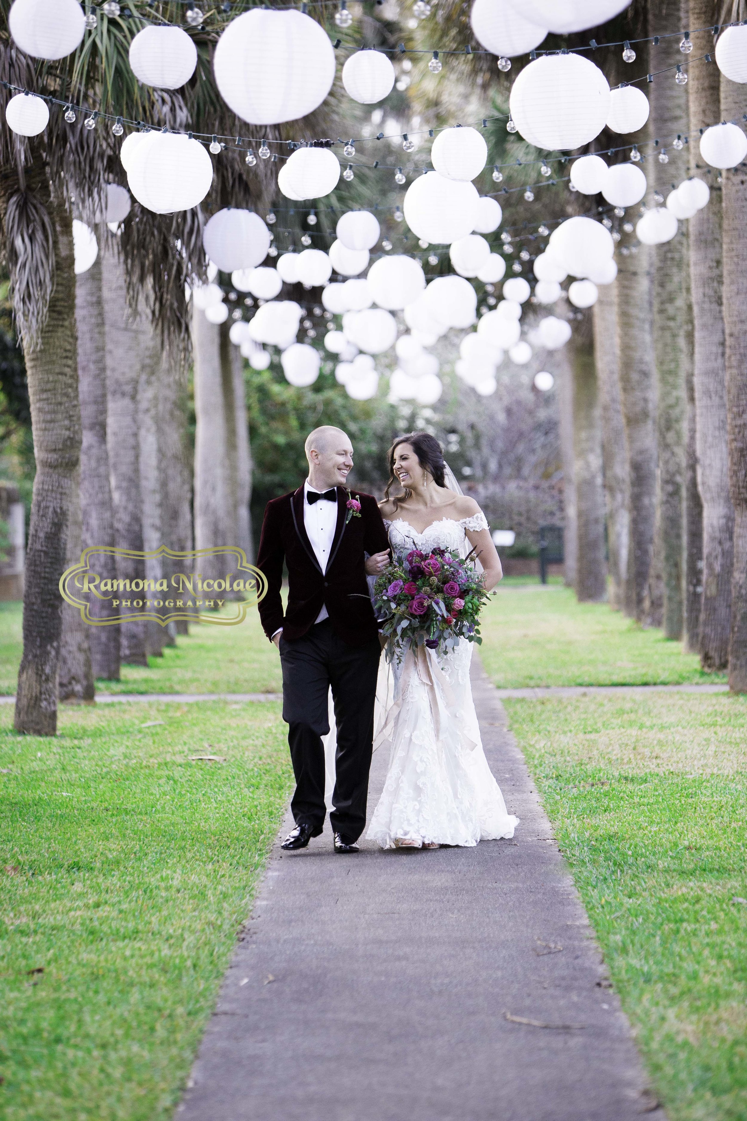 bride and groom walking at brookgreen gardens on their wedding day laughing holding wedding bouquet.jpg
