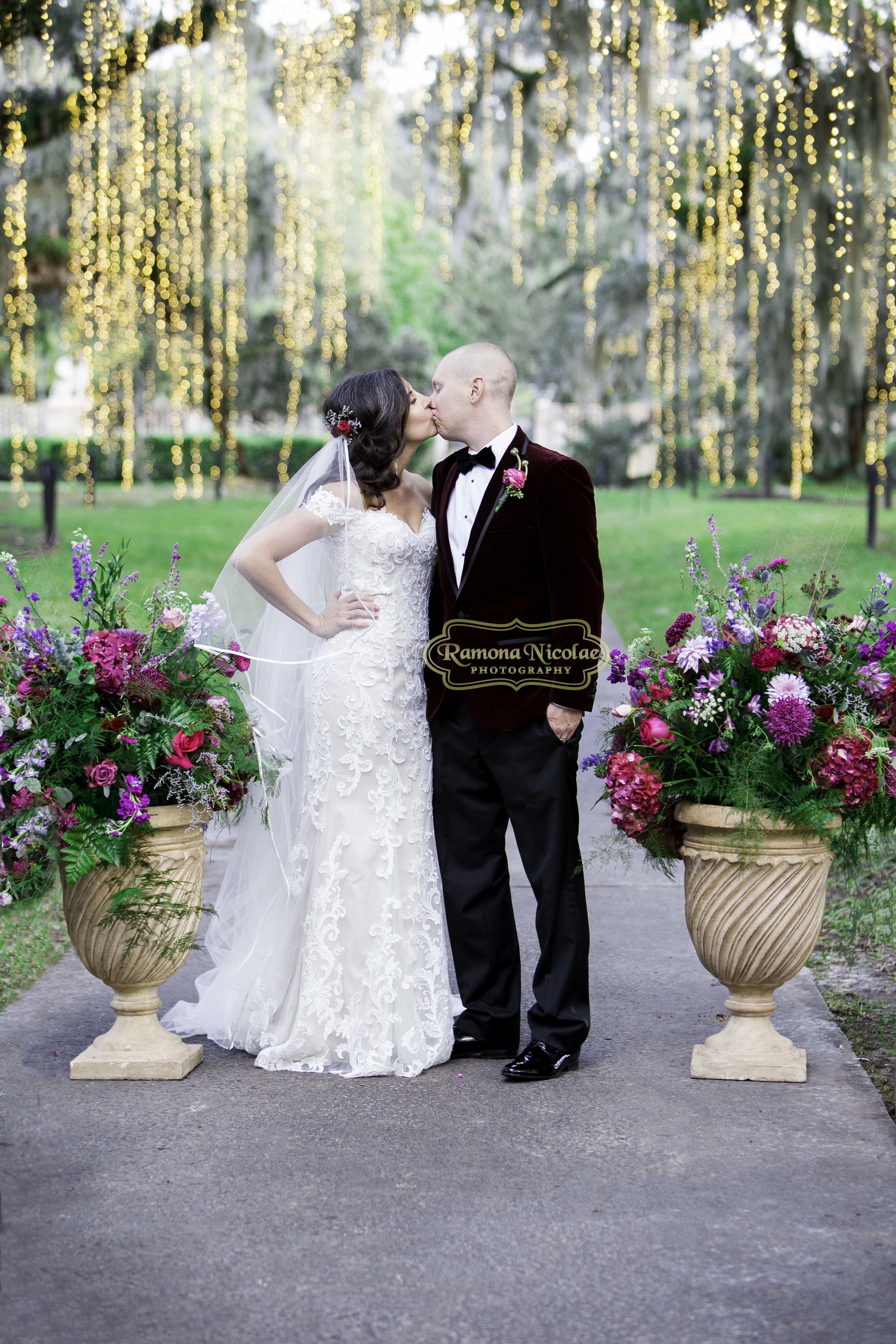 bride and groom kissing at brookgreen gardens during night of thousand lights after their wedding.jpg