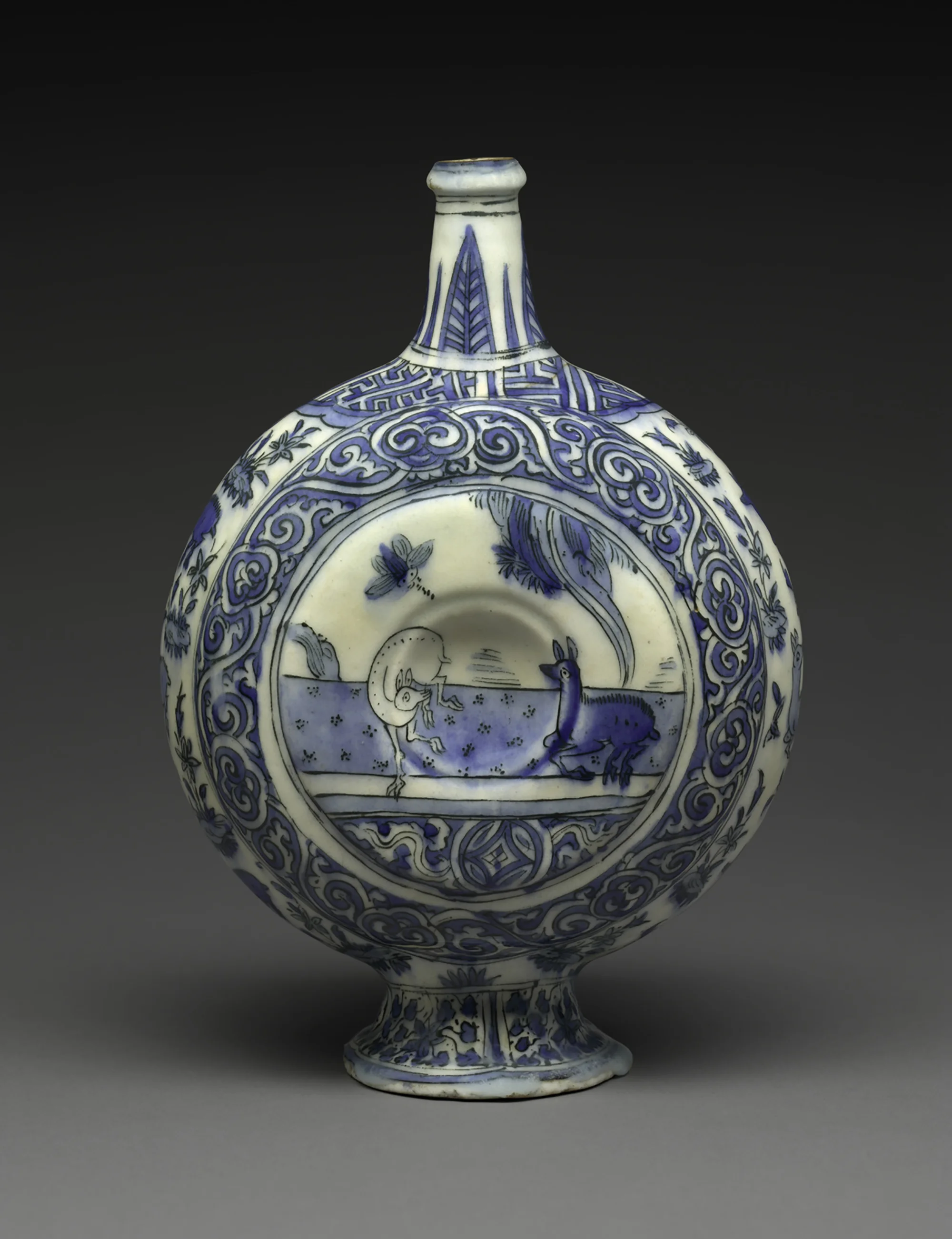 A blue and white porcelain vase with intricate patterns, featuring a circular scene with animals and floral motifs, and a narrow neck with decorative lines.