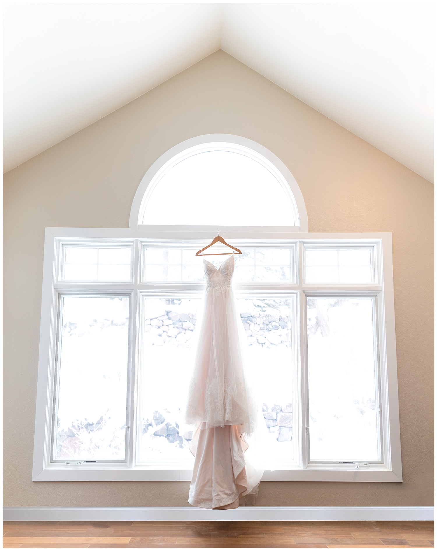 Wedding dress hanging in a brightly lit window
