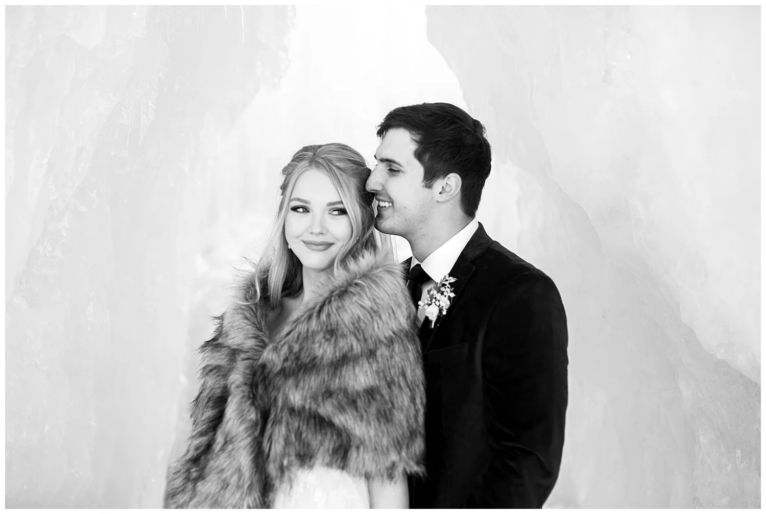 a groom whispers sweet nothings into his bride’s ear
