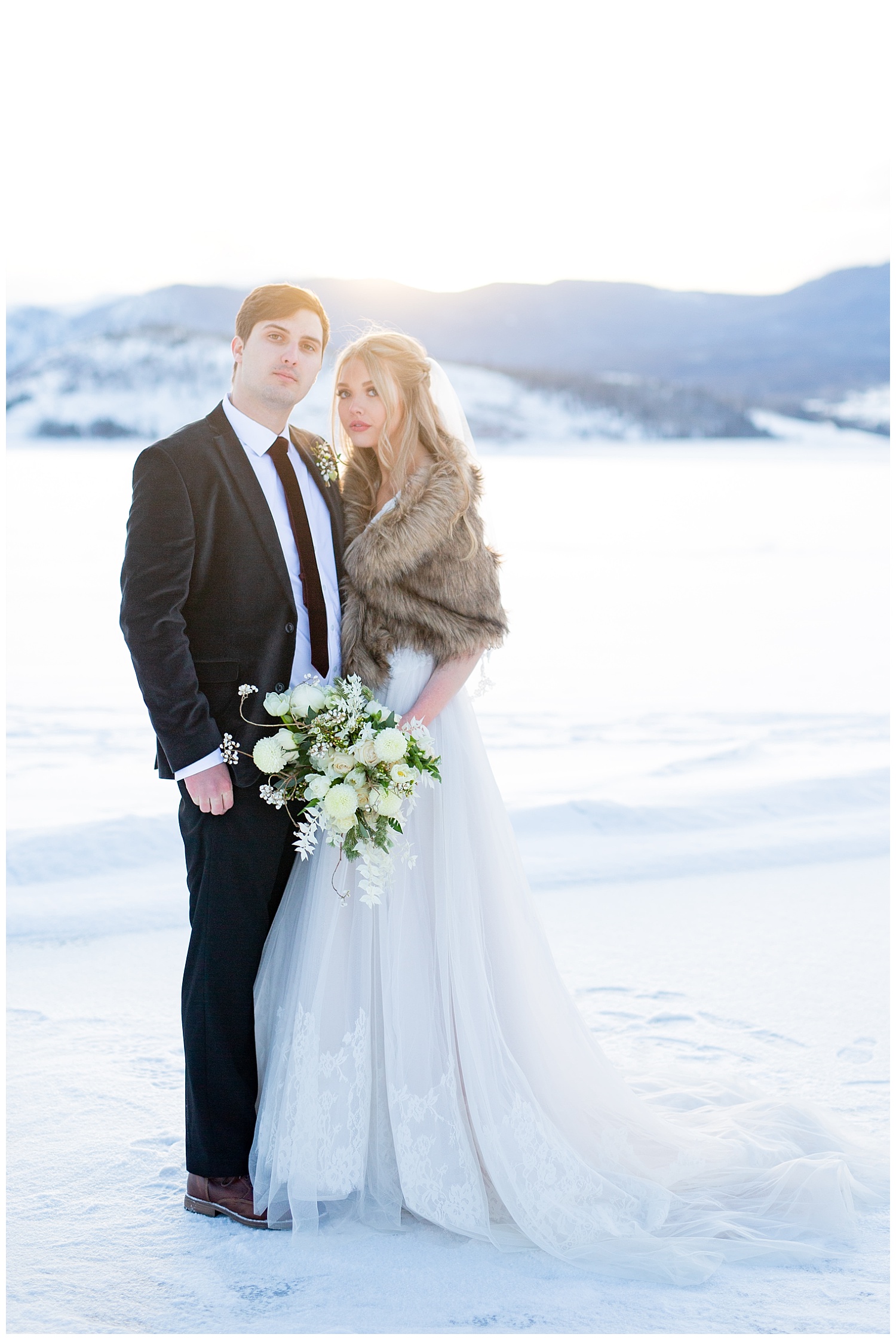 A bride and groom on a snowy lake in the middle of winter