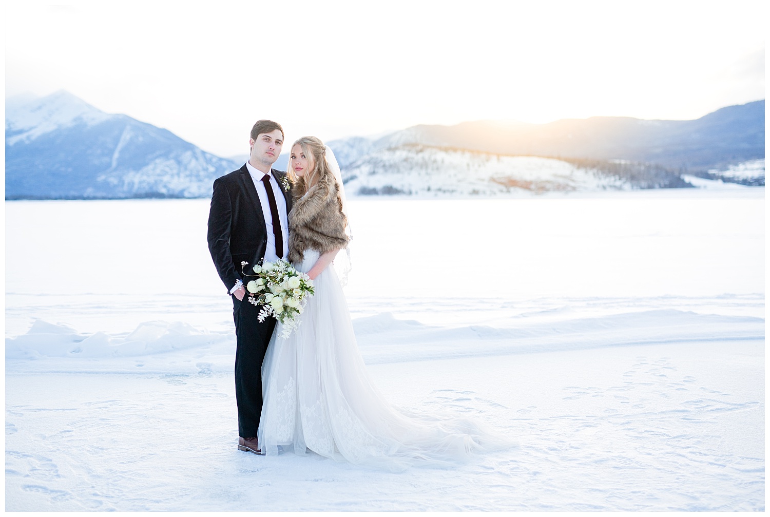 A bride and groom looking straight at the camera in a winter photoshoot