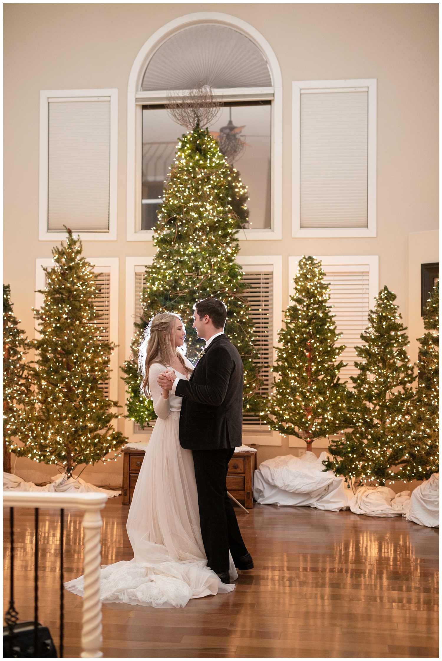 The bride and groom share their first dance surrounded by Christmas trees