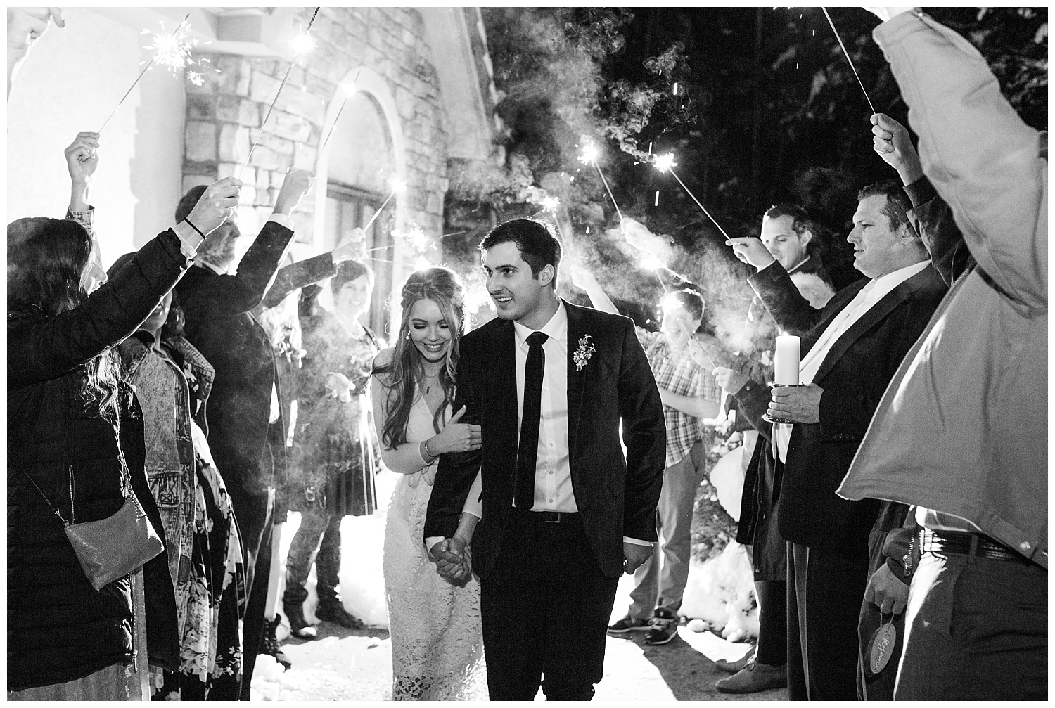 All of the wedding guests cheer for the bride and groom during their sparkler exit