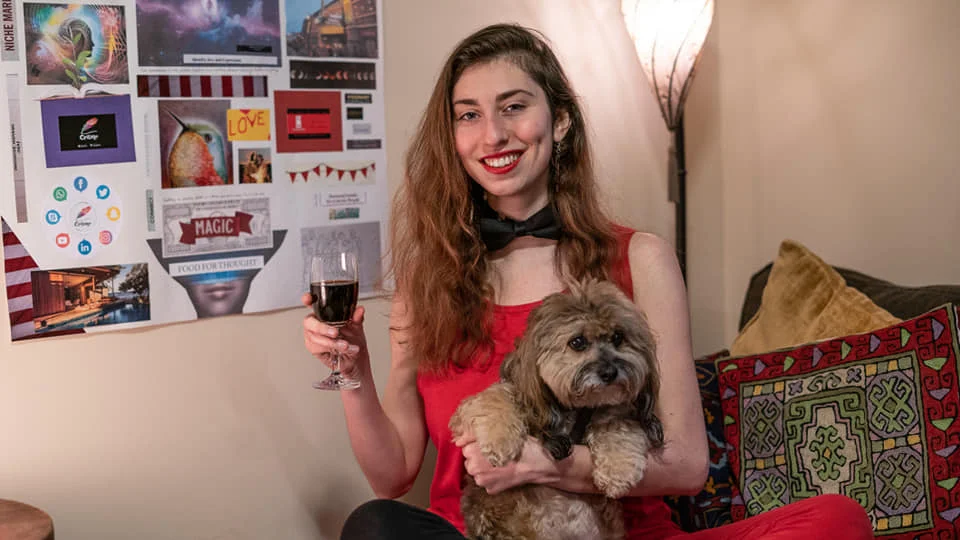 All Around Artsy Owner / Director Kira Bursky with her dog Alfie in front of her 2019 Vision Board on New Year’s Day.