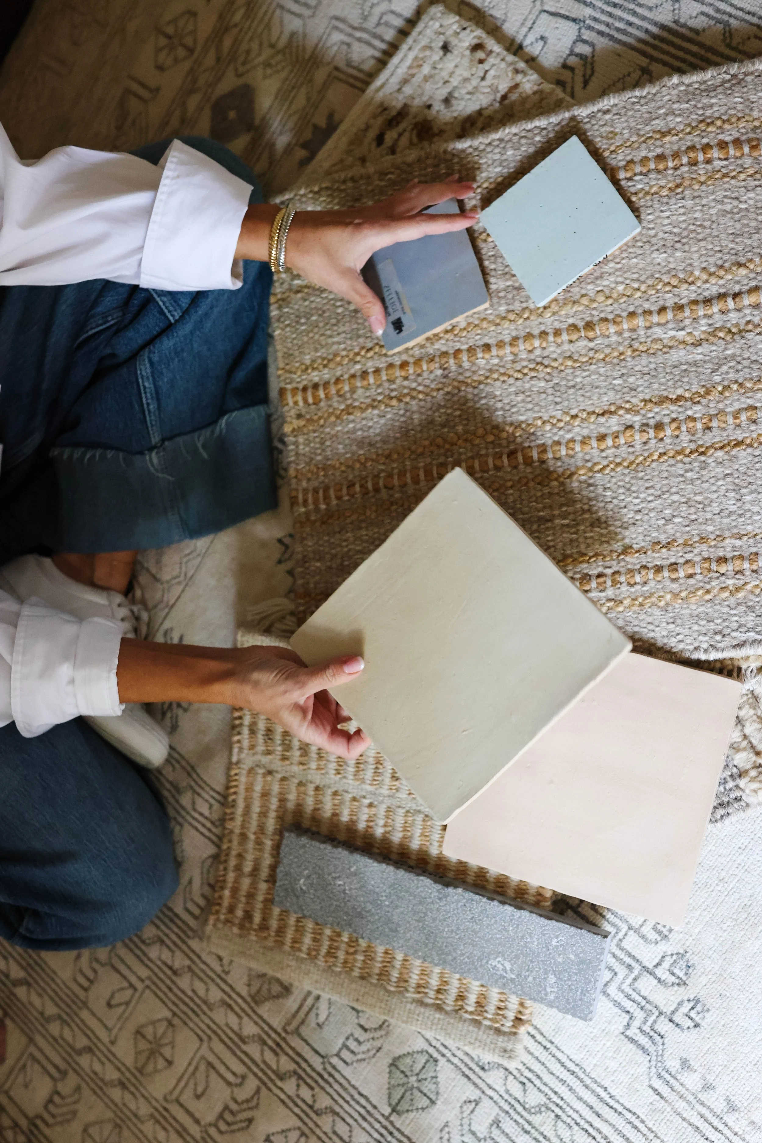Close up shot of interior designer holding tile sampling while sitting on the floor.