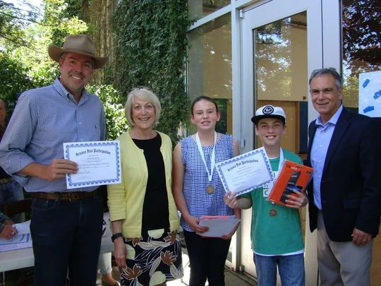 Napa Valley Unified School District Superintendent Patrick Sweeney, right, and Napa Mayor Jill Techel, second from left, honored Napa Valley Science Fair Grand Prize Winners Shane McGrath (First Christian School, Napa), Wyntress Mehelis (First Christian School, Napa) and Eva Wendel (Blue Oak School, Napa). Eva's father Chris, left, filled in for her as she had to leave early for a Lacross match. Image: Samie Hartley, Napa Valley Register.