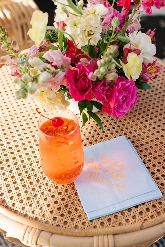 shirley-temple-on-rattan-table-with-floral-arrangement-and-custom-napkins.jpg