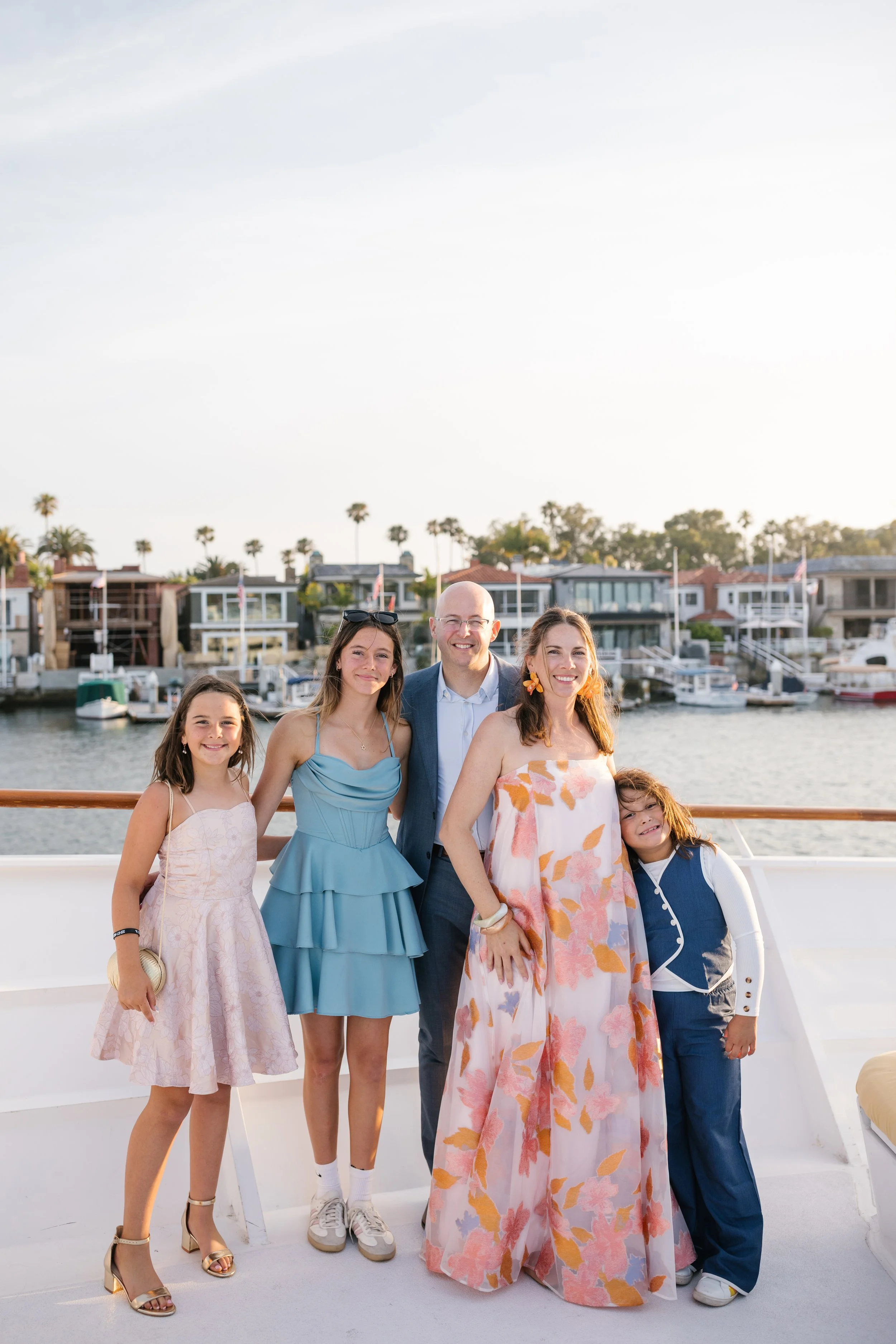 family-portrait-of-parents-and-three-daughters-all-dressed-up-on-a-boat.jpg
