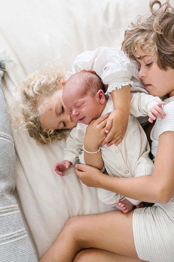 newborn-snuggled-with-big-brother-and-sister.jpg