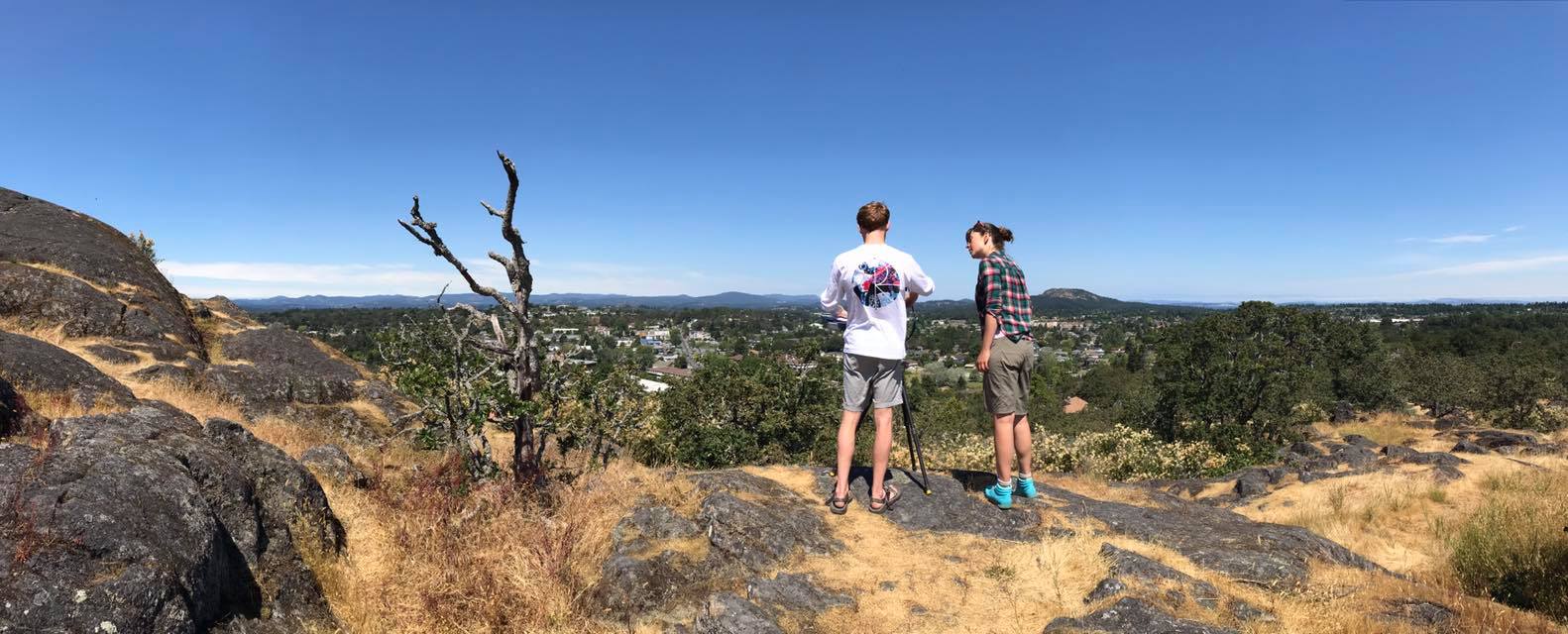 Karson Sudlow (left) and Sonia Voicescu (right) practice with the photography equipment on Mt. Tolmie in Victoria before heading into the field. Photo by Mary Sanseverino (Mountain Legacy Project).