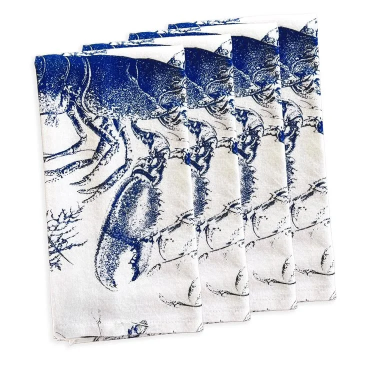 Blue and white cotton dinner napkins with lobster motif, stacked set of four on a clean white background