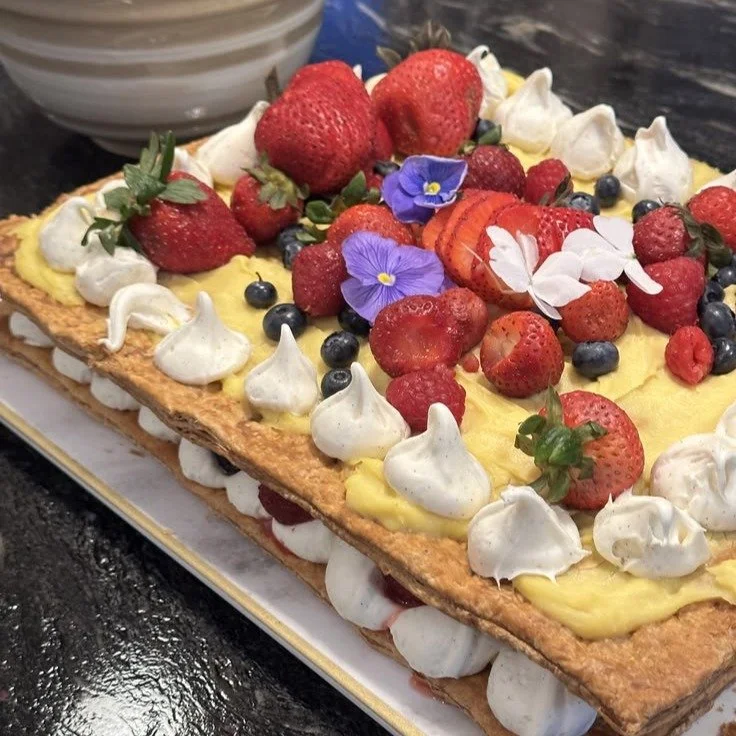 When the room went quiet, I knew it had worked.

I carried this to the table, a French mille-feuille, two golden layers of all-butter puff pastry, filled with a from-scratch cr&egrave;me p&acirc;tissi&egrave;re and a vanilla buttercream border to hol