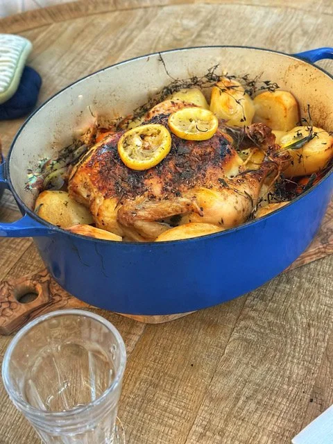 Golden French roast chicken with vermouth fresh herbs and root vegetables served from a blue Le Creuset — Sunday slow living recipe from Merze Lifestyle