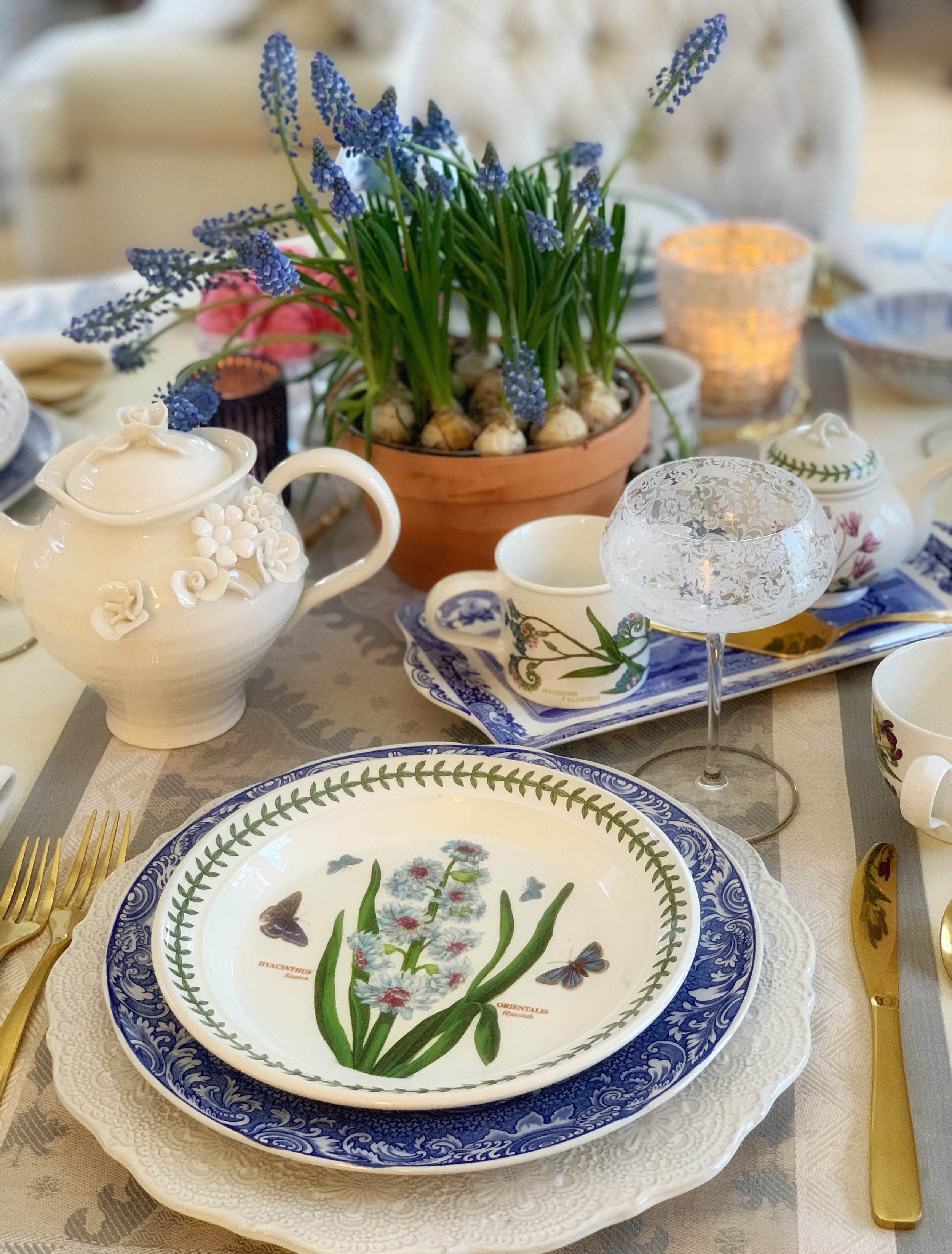 spring table detail with teapot cream and sugar set blue and white platter and grape hyacinth flowers