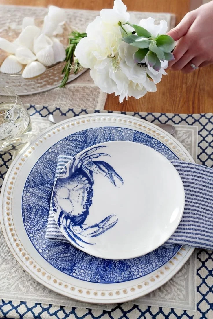 Blue crab porcelain plate styled outdoors with hydrangeas in relaxed coastal setting