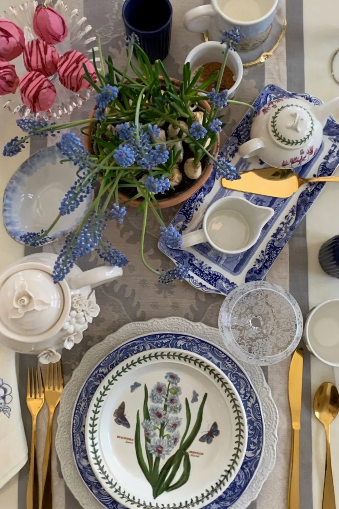spring tablescape with grape hyacinth centerpiece etched wine glasses teapot and blue and white china