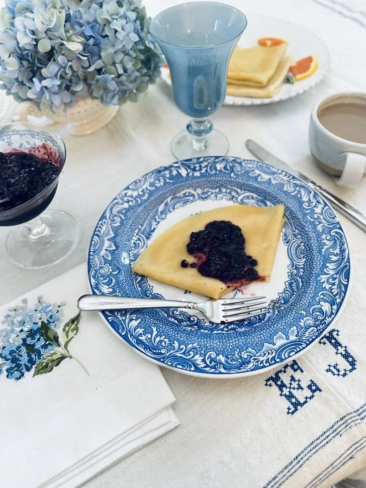 Berry compote spooned over a crêpe de froment on a blue and white plate