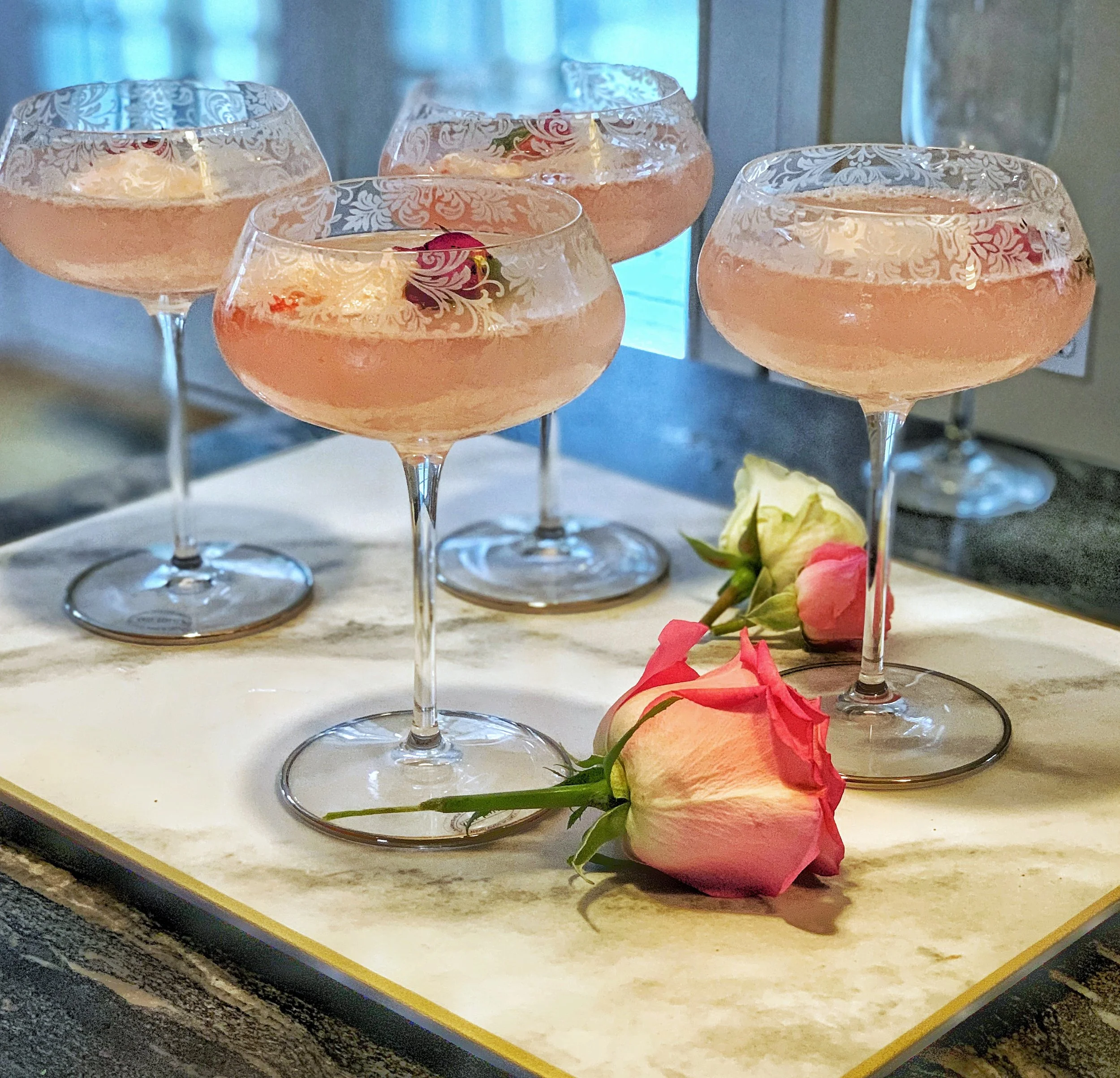 Set of etched wine glasses filled with rose sherbet punch, styled for spring entertaining and an elegant Easter high tea table.