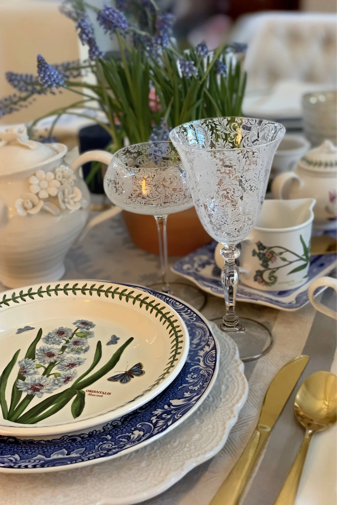 spring place setting with etched wine glass blue and white china and botanical plate with grape hyacinth