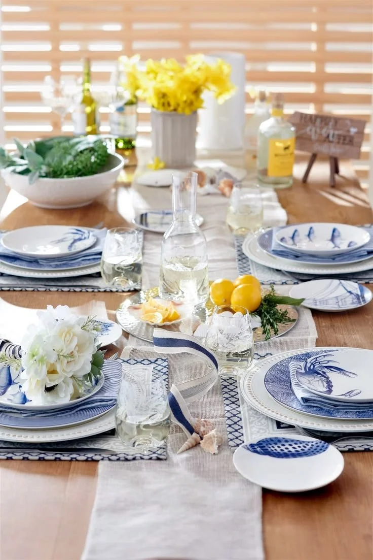 Blue crab accent plate layered on blue white and yellow coastal tablescape outdoors