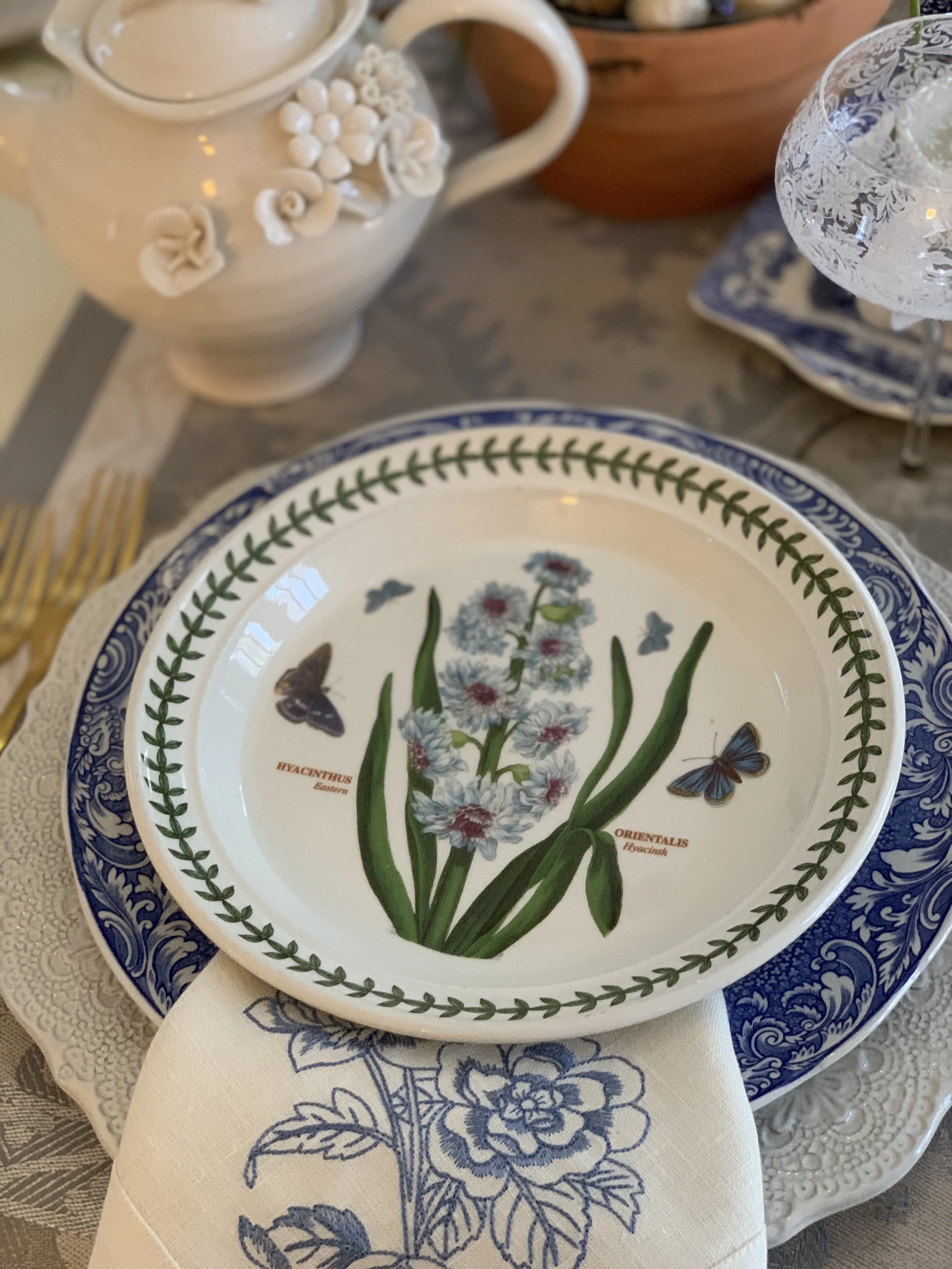 close up of botanical place setting with layered plates and grape hyacinth spring centerpiece