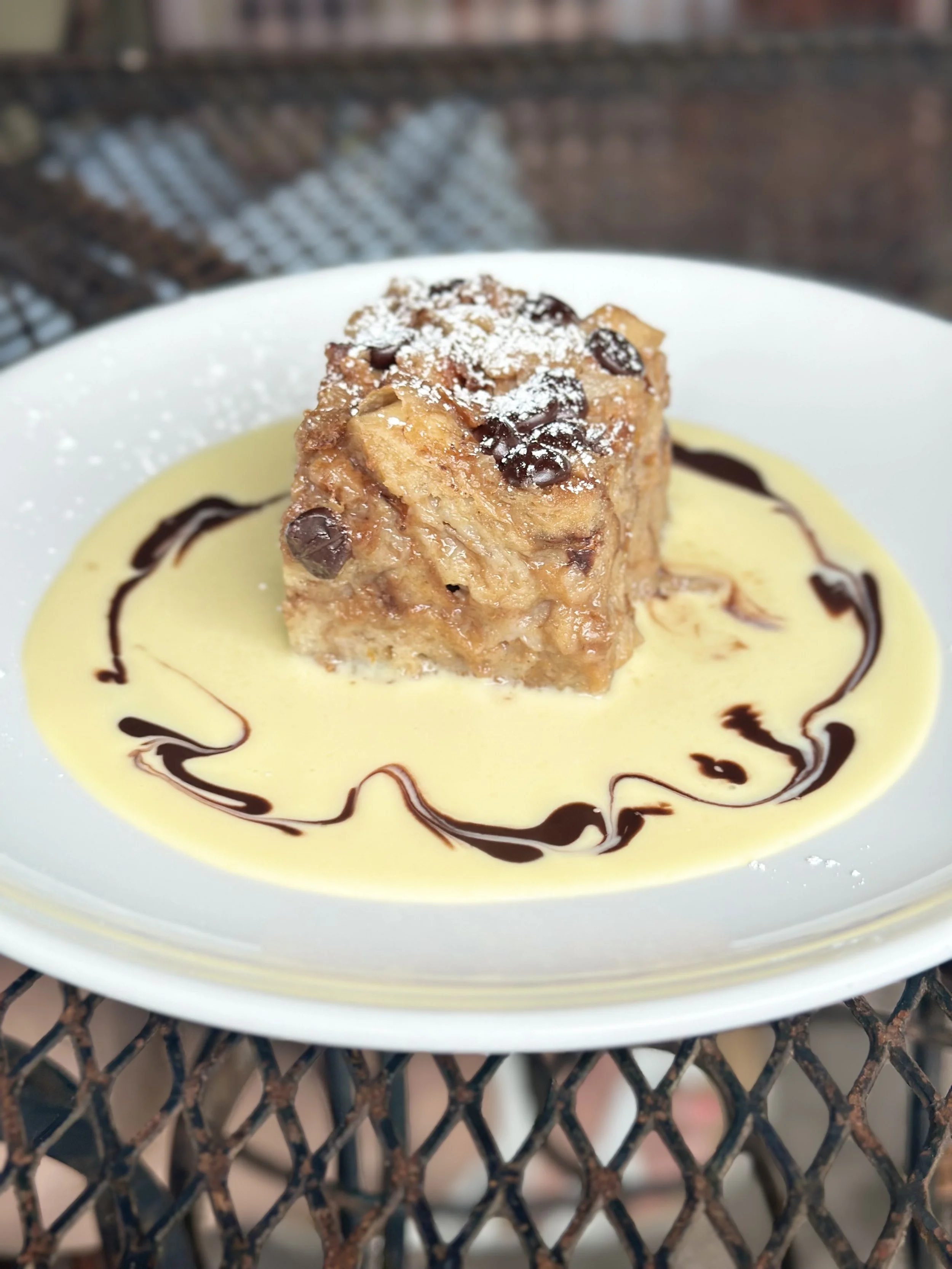 Warm bread pudding with chocolate and powdered sugar in a pool of crème anglaise at Le Gamin café in Sharon, Connecticut