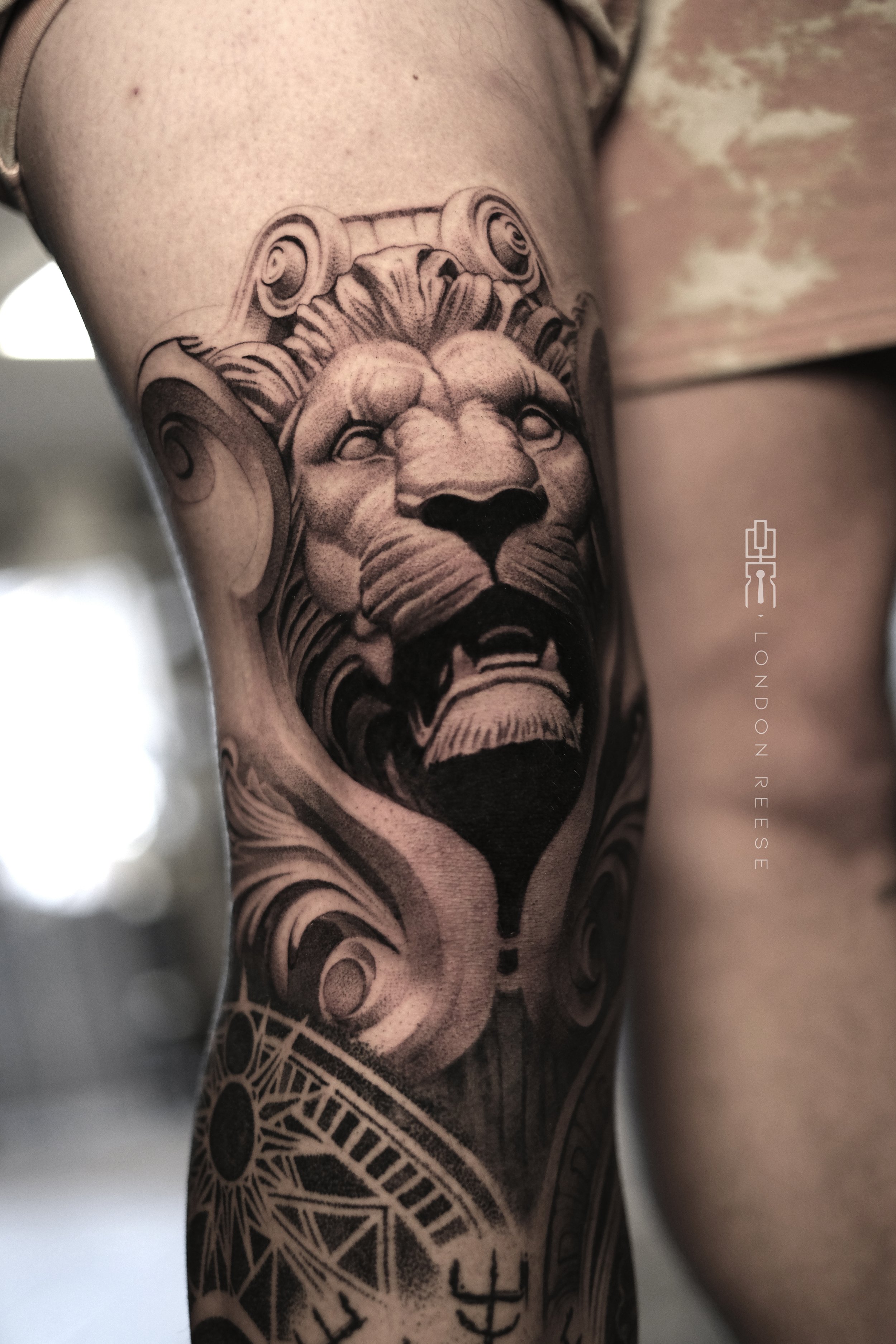 lion statue relief knee cap tattoo.jpg