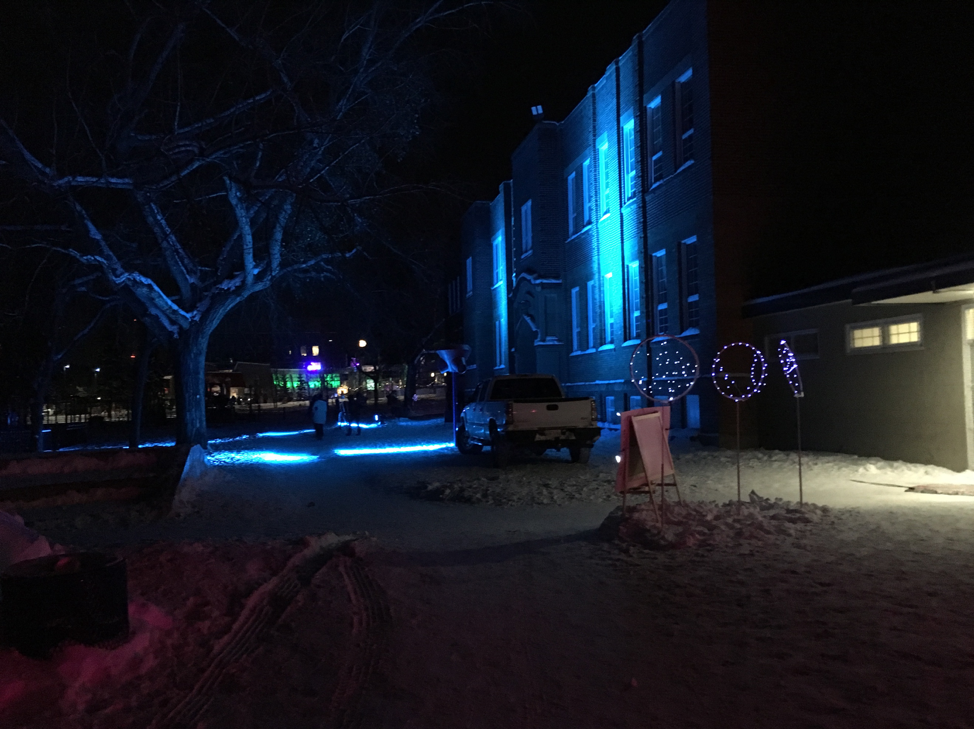 Rutherford School lit up with changing coloured lights, used as "warming station" for people about to head down to the Ravine trails. 
