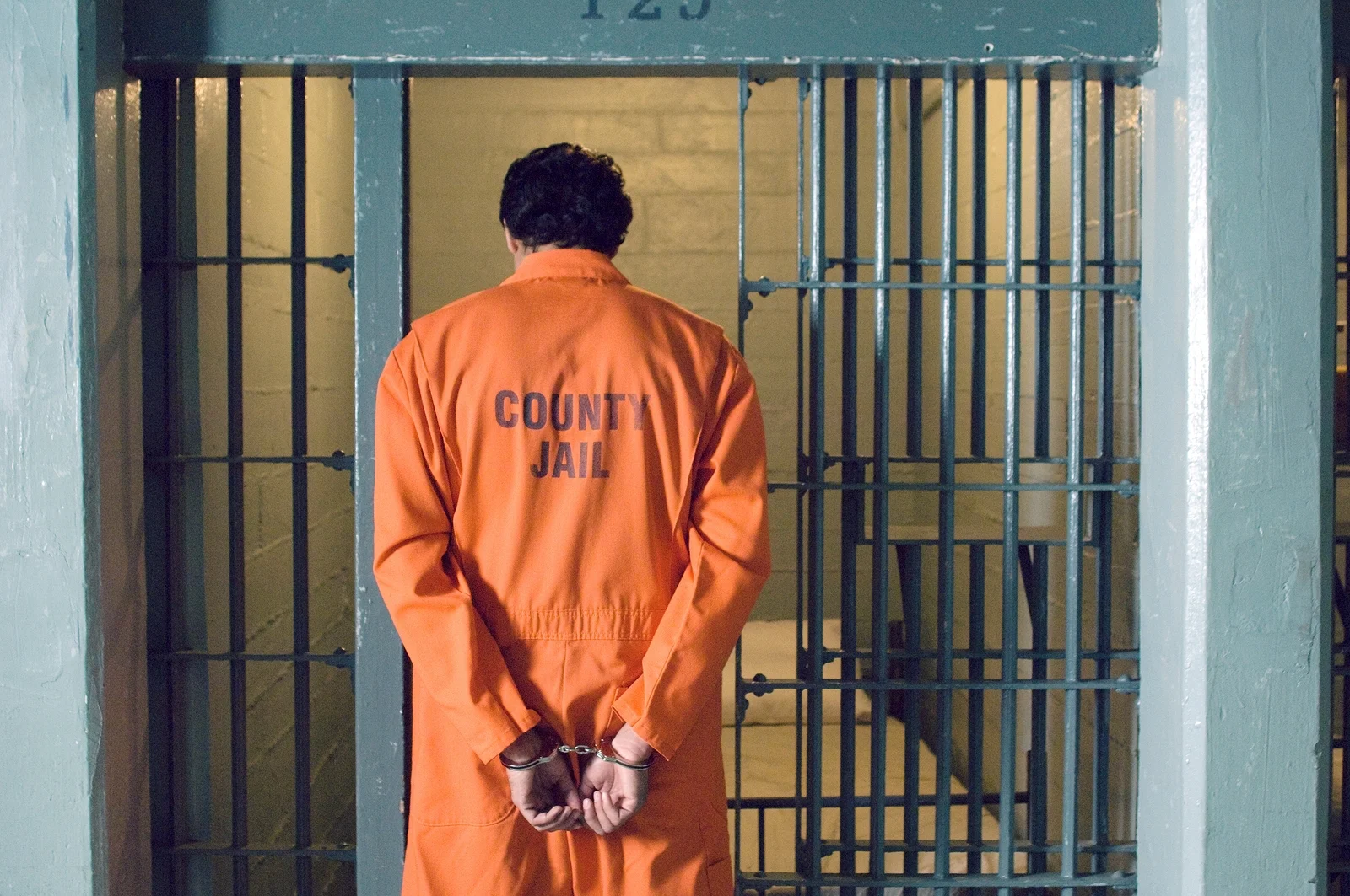 bigstock-Handcuffed-prisoner-in-jail-194498938.jpg
