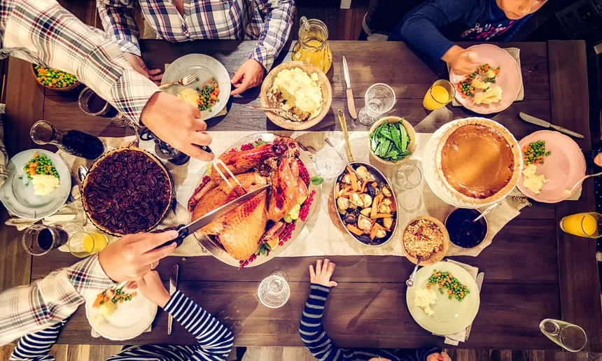 A family having a traditional holiday dinner with stuffed turkey, mashed potatoes, cranberry sauce, vegetables, pumpkin and pecan pie. Photograph: GMVozd/Getty Images
