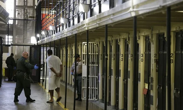  An inmate is led out of his cell at an American prison. Photograph: Eric Risberg/AP