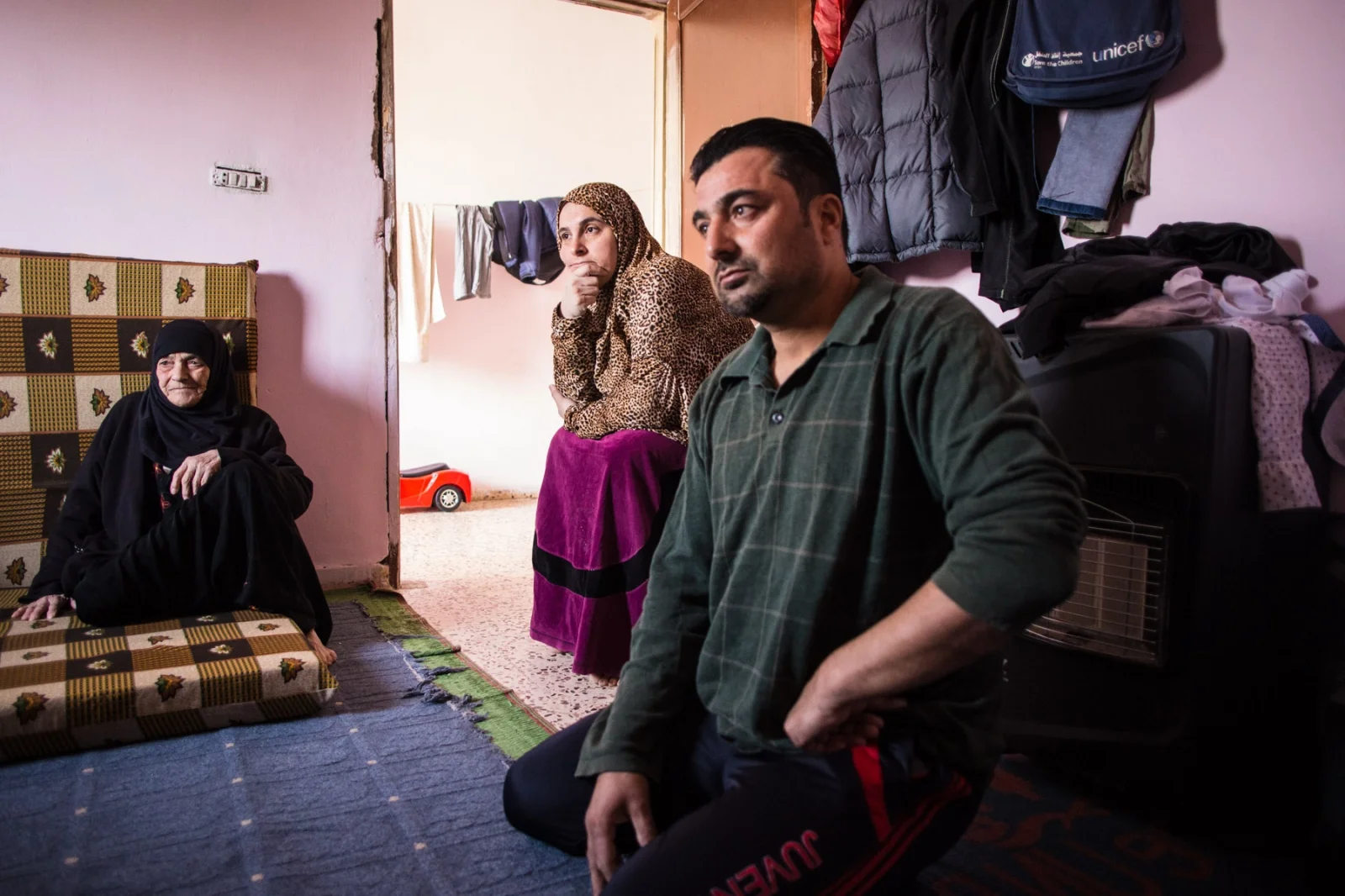 Ahmed Jansis, 41, sits with his wife Um Mohammed, mother, and son Hamzah at home in Mafraq, Jordan, on Nov. 4, 2016. The family came from Aleppo, where Um Mohammed worked as an English teacher, and now both parents do odd jobs to earn a basic income for the family.