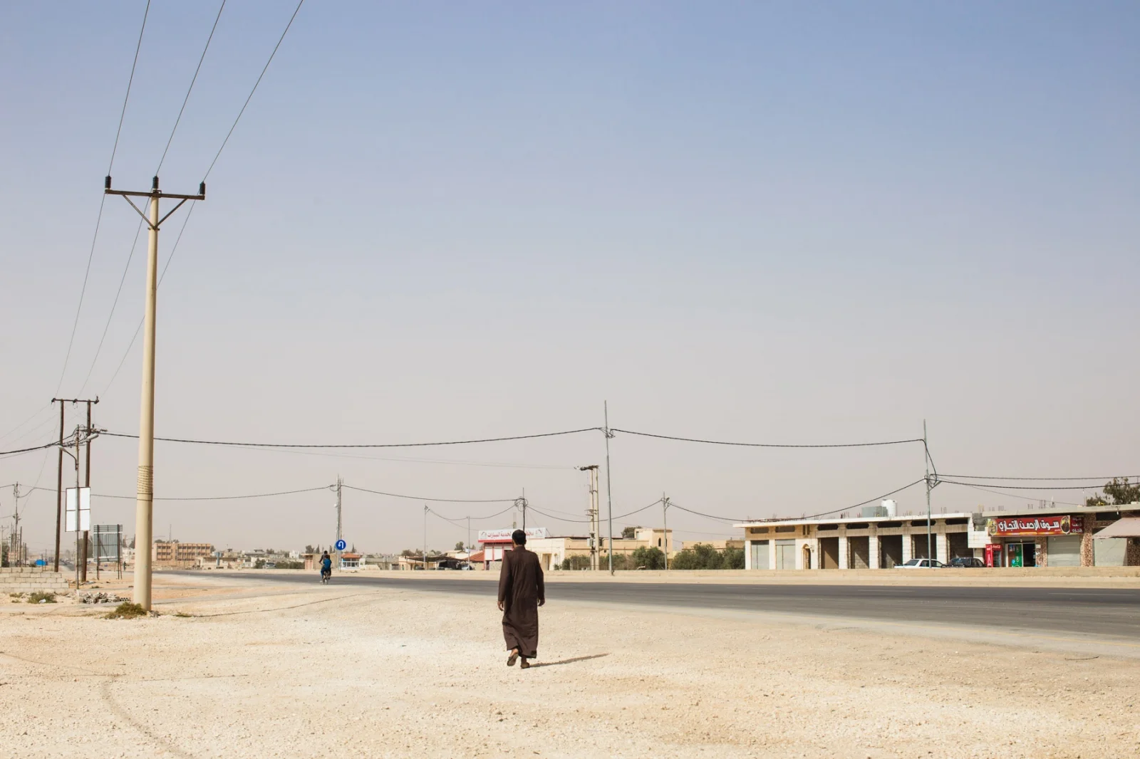 A man walks along the desert stretch of road outside of Za’atari Refugee Camp in northern Jordan.