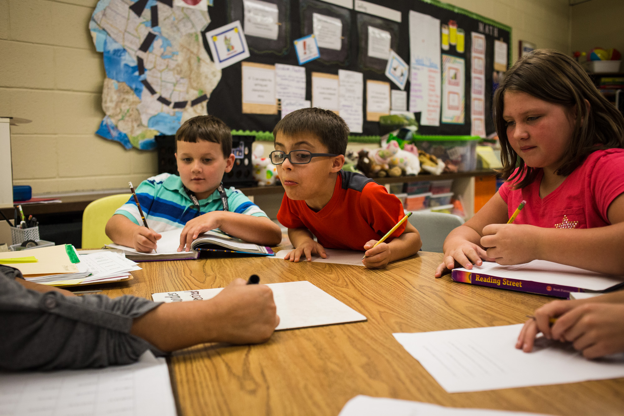 Treven peers at his teacher’s paper during writing practice in English class at Perryville Elementary School. Treven was diagnosed with a rare form of Down’s Syndrome as an infant and struggles to catch up with writing and speech.